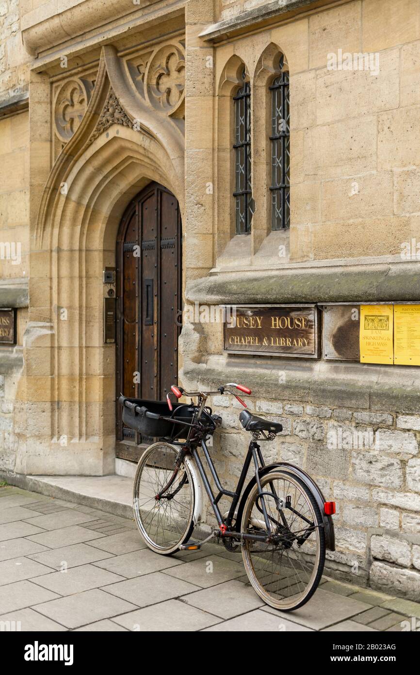 Bici dello studioso che riposa contro il muro della Cappella e della Biblioteca di Pusey House, l'università di Oxord, l'Inghilterra Foto Stock