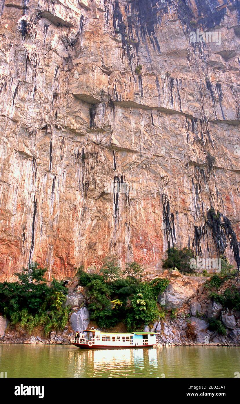 Cina: Barca sotto i dipinti della scogliera di Huashan (Huashan Bihua), fiume Zuo (Zuo Jiang), riserva naturale di Longrui, provincia del Guangxi. I dipinti della scogliera Huashan si trovano lungo il fiume Zuo nella provincia del Guangxi e si ritiene che abbiano circa 2000 anni. Ci sono 60 dipinti in tutto con un totale di 1.770 figure umane. I dipinti furono eseguiti dal popolo Luoyue, antenati della locale minoranza Zhuang. Lo Zuojiang o fiume Zuo (letteralmente "fiume sinistro") è un fiume della provincia del Guangxi, nella Cina meridionale. Sfocia nel Mar Cinese meridionale. Foto Stock