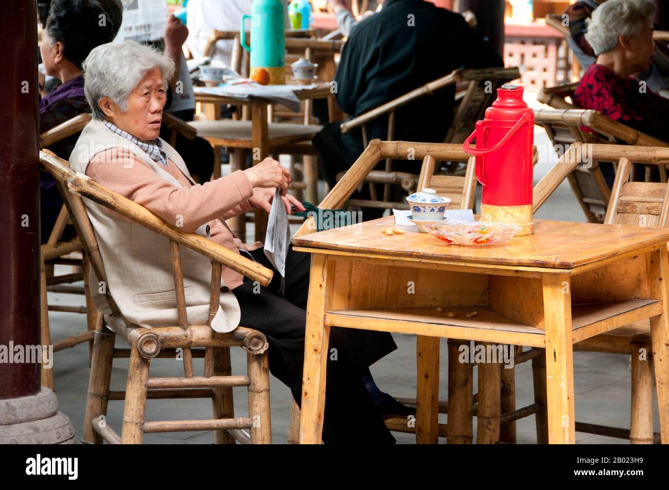Cina: Leggere il giornale in una casa da tè a Renmin Gongyuan (Parco del popolo), Chengdu, provincia del Sichuan. Chengdu, precedentemente nota come Chengtu, è la capitale della provincia del Sichuan nel sud-ovest della Cina. All'inizio del IV secolo a.C., il IX re Kaiming dell'antico Shu trasferì la sua capitale nella posizione attuale della città dall'attuale vicino Pixian. Secondo la tradizione orale, il tè è stato coltivato in Cina per più di quattro millenni. I primi resoconti scritti sulla preparazione del tè, tuttavia, risalgono al 350 d.C. circa, quando divenne per la prima volta una bevanda alla corte imperiale. Foto Stock