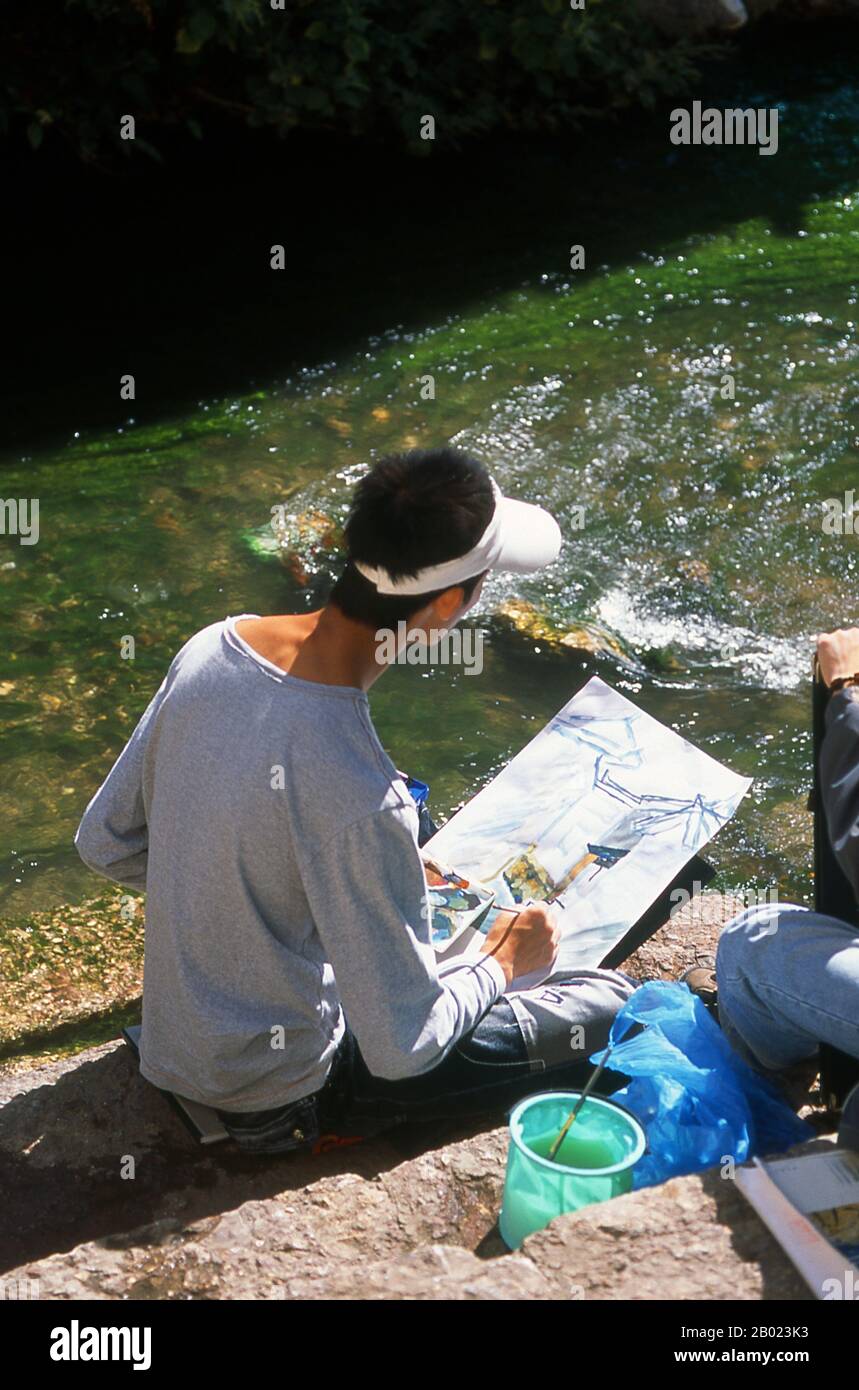 Cina: Schizzi di artisti nella città vecchia di Lijiang, provincia dello Yunnan. I Naxi o Nakhi sono un gruppo etnico che abita le colline pedemontane dell'Himalaya nella parte nord-occidentale della provincia dello Yunnan, così come la parte sud-occidentale della provincia del Sichuan in Cina. Si pensa che i Naxi provengano dal Tibet e, fino a poco tempo fa, mantennero legami commerciali via terra con Lhasa e India. I Naxi formano uno dei 56 gruppi etnici ufficialmente riconosciuti dalla Repubblica Popolare Cinese. I Naxi sono tradizionalmente seguaci della religione Dongba. Foto Stock