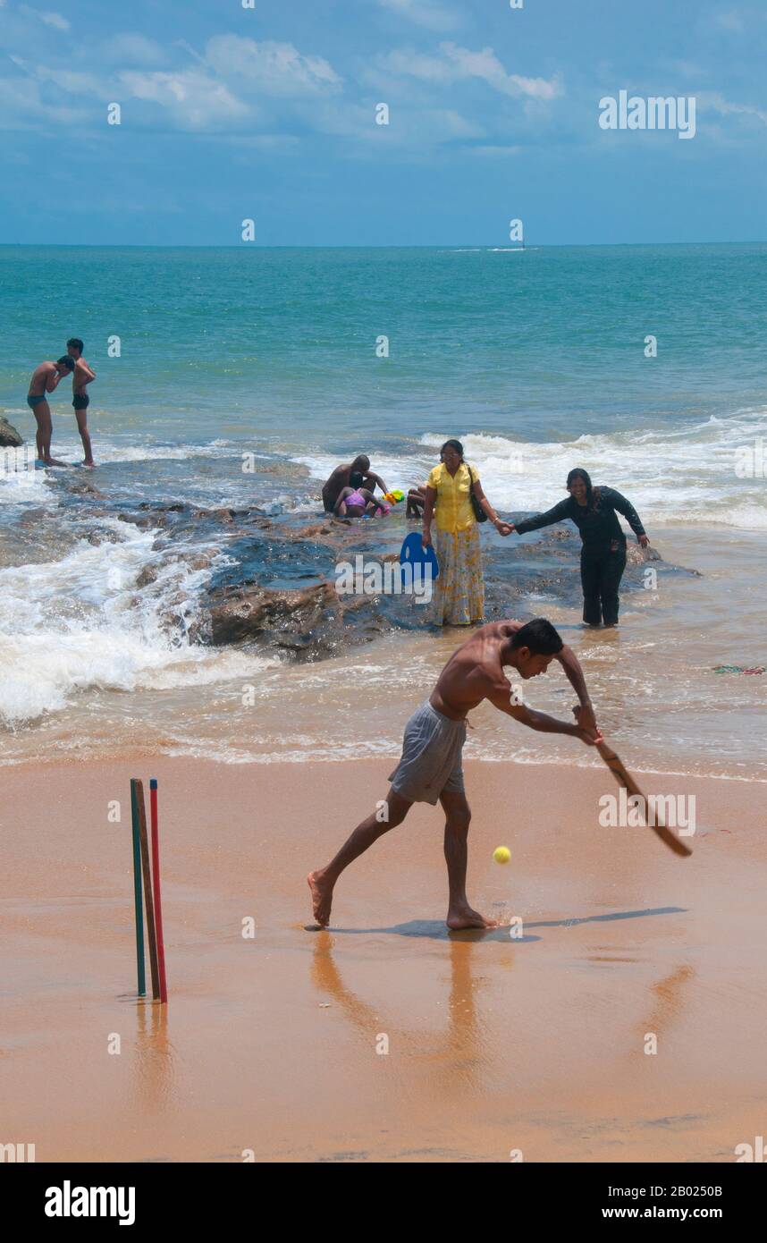Sri Lanka: Cricket giocato sulla spiaggia del Monte Lavinia, a sud di Colombo. Il cricket è lo sport più popolare dello Sri Lanka. Lo Sri Lanka è una delle dieci nazioni che partecipano ai test di cricket e una delle cinque nazioni che hanno vinto una coppa del mondo di cricket. Il cricket è giocato a livello professionale, semi-professionale e ricreativo nel paese e le partite di cricket internazionali sono osservate con interesse da una grande parte della popolazione. Il cricket fu portato per la prima volta sull'isola dagli inglesi e si ritiene che sia stato giocato lì intorno al 1800. Foto Stock