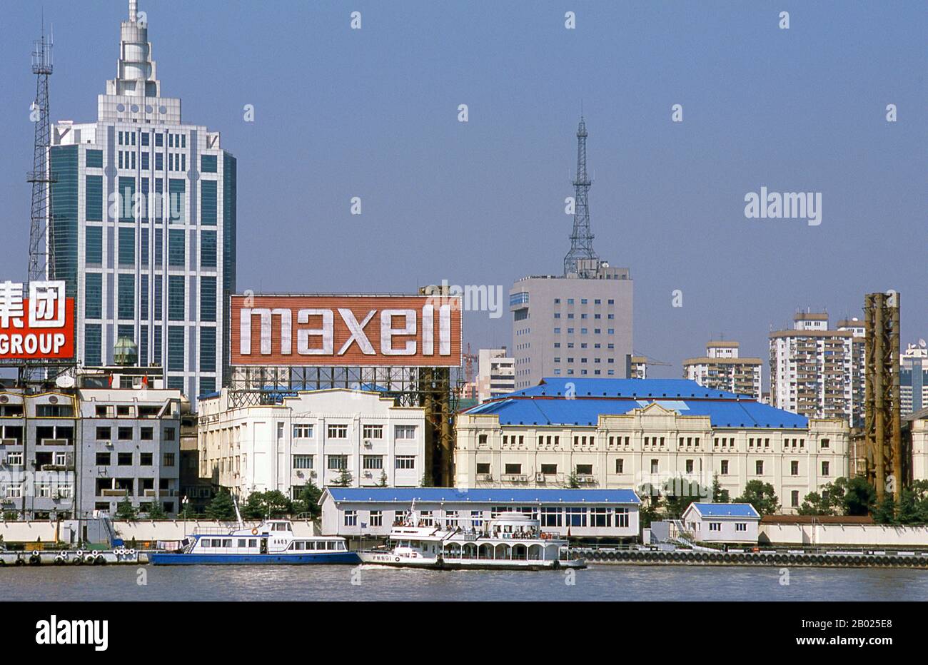 Cina: Traffico commerciale sul fiume Huangpu, Shanghai, 2000. Shanghai iniziò la sua vita come villaggio di pescatori, e più tardi come porto che riceveva merci trasportate lungo il fiume Yangzi. Dal 1842 in poi, dopo la prima guerra dell'oppio, i britannici aprirono una "concessione" a Shanghai, dove i trafficanti di droga e altri commercianti potevano operare indisturbati. Francesi, italiani, tedeschi, americani e giapponesi seguirono tutti. Negli anni '1920 e '1930, Shanghai era una città boom e una parola d'ordine internazionale per la dissipazione. Quando i comunisti conquistarono il potere nel 1949, trasformarono Shanghai in un modello della rivoluzione. Foto Stock