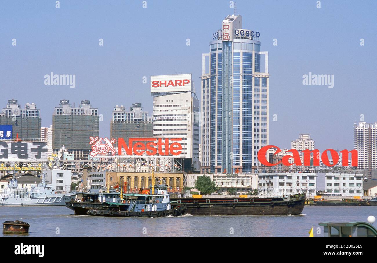 Cina: Traffico commerciale sul fiume Huangpu, Shanghai, 2000. Shanghai iniziò la sua vita come villaggio di pescatori, e più tardi come porto che riceveva merci trasportate lungo il fiume Yangzi. Dal 1842 in poi, dopo la prima guerra dell'oppio, i britannici aprirono una "concessione" a Shanghai, dove i trafficanti di droga e altri commercianti potevano operare indisturbati. Francesi, italiani, tedeschi, americani e giapponesi seguirono tutti. Negli anni '1920 e '1930, Shanghai era una città boom e una parola d'ordine internazionale per la dissipazione. Quando i comunisti conquistarono il potere nel 1949, trasformarono Shanghai in un modello della rivoluzione. Foto Stock