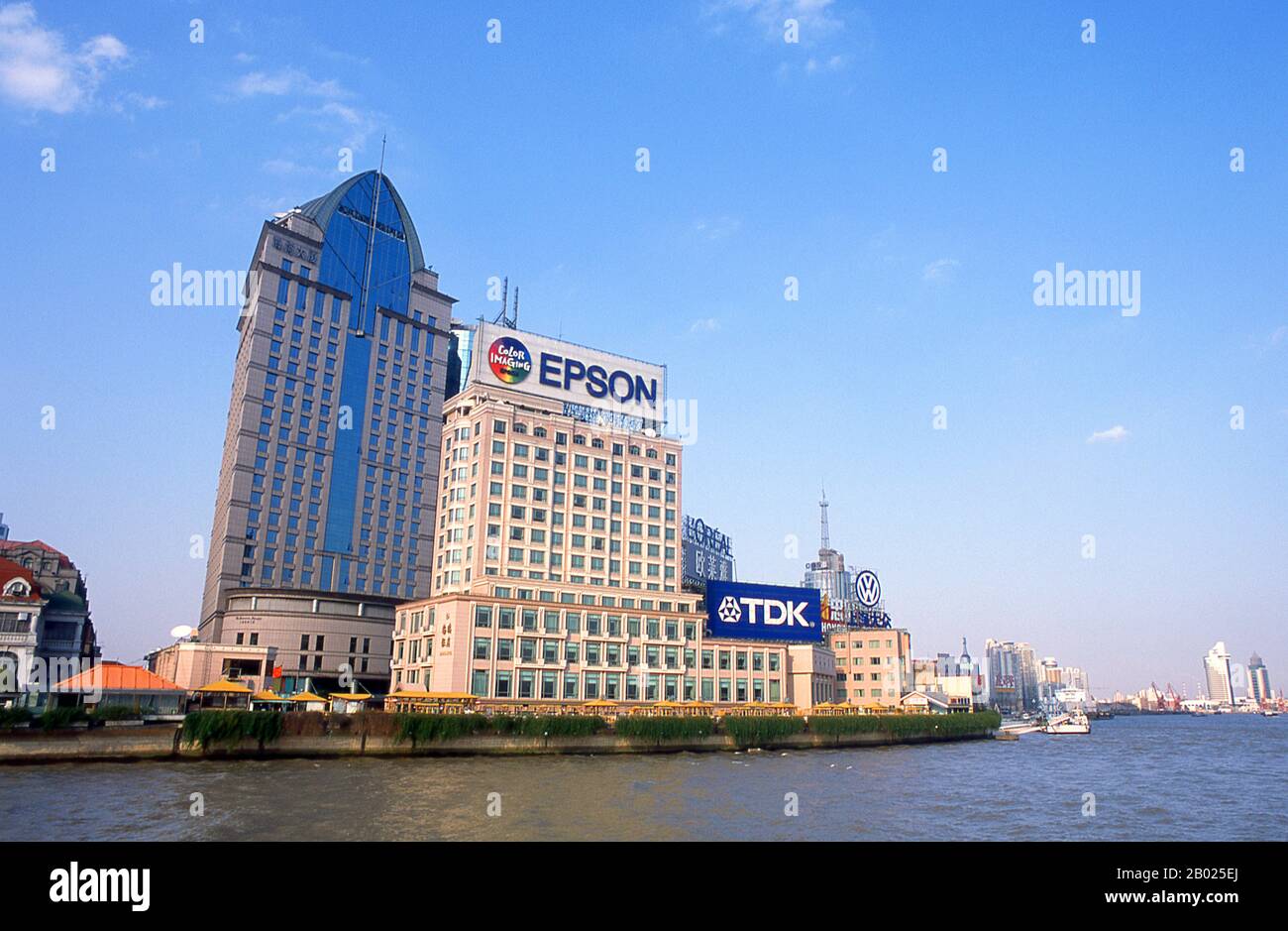 Cina: Il Panorama Hotel e il lungofiume Huangpu, Shanghai, 2000. Shanghai iniziò la sua vita come villaggio di pescatori, e più tardi come porto che riceveva merci trasportate lungo il fiume Yangzi. Dal 1842 in poi, dopo la prima guerra dell'oppio, i britannici aprirono una "concessione" a Shanghai, dove i trafficanti di droga e altri commercianti potevano operare indisturbati. Francesi, italiani, tedeschi, americani e giapponesi seguirono tutti. Negli anni '1920 e '1930, Shanghai era una città boom e una parola d'ordine internazionale per la dissipazione. Foto Stock