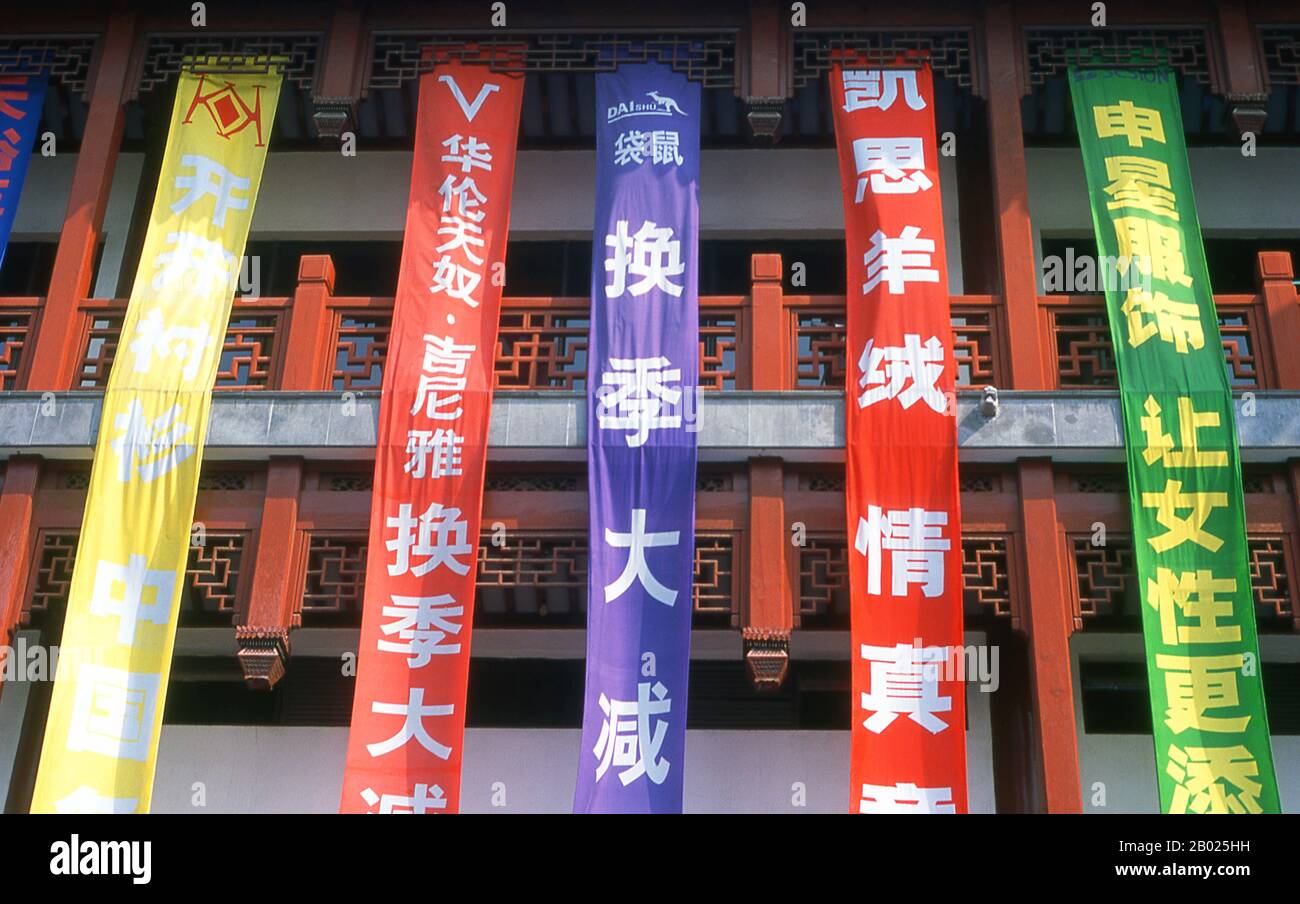 Cina: Bandiere colorate appese agli edifici della zona del Bazaar Yuyuan, Nanshi o della città Vecchia, Shanghai. Shanghai iniziò la sua vita come villaggio di pescatori, e più tardi come porto che riceveva merci trasportate lungo il fiume Yangzi. Dal 1842 in poi, dopo la prima guerra dell'oppio, i britannici aprirono una "concessione" a Shanghai, dove i trafficanti di droga e altri commercianti potevano operare indisturbati. Francesi, italiani, tedeschi, americani e giapponesi seguirono tutti. Negli anni '1920 e '1930, Shanghai era una città boom e una parola d'ordine internazionale per la dissipazione. Foto Stock