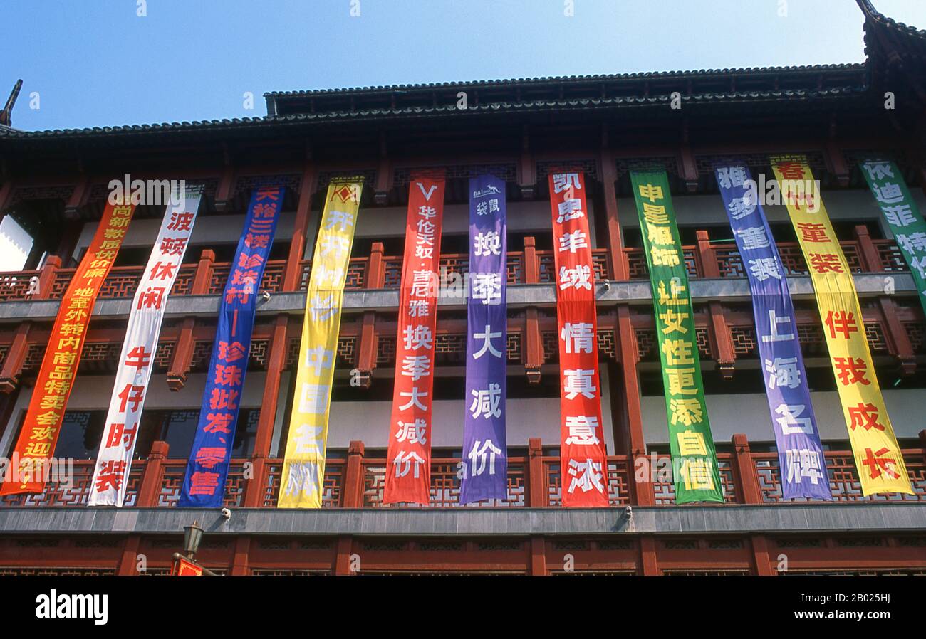 Cina: Bandiere colorate appese agli edifici della zona del Bazaar Yuyuan, Nanshi o della città Vecchia, Shanghai. Shanghai iniziò la sua vita come villaggio di pescatori, e più tardi come porto che riceveva merci trasportate lungo il fiume Yangzi. Dal 1842 in poi, dopo la prima guerra dell'oppio, i britannici aprirono una "concessione" a Shanghai, dove i trafficanti di droga e altri commercianti potevano operare indisturbati. Francesi, italiani, tedeschi, americani e giapponesi seguirono tutti. Negli anni '1920 e '1930, Shanghai era una città boom e una parola d'ordine internazionale per la dissipazione. Foto Stock