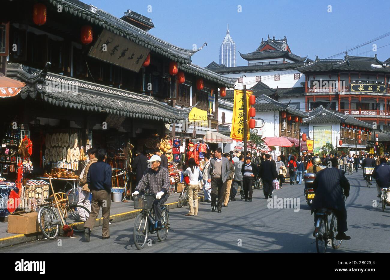 Cina: Scena di strada di Fangbang Lu con la Torre Jin Mao sullo sfondo (Pudong), Nanshi o la zona della città Vecchia, Shanghai. Shanghai iniziò la sua vita come villaggio di pescatori, e più tardi come porto che riceveva merci trasportate lungo il fiume Yangzi. Dal 1842 in poi, dopo la prima guerra dell'oppio, i britannici aprirono una "concessione" a Shanghai, dove i trafficanti di droga e altri commercianti potevano operare indisturbati. Francesi, italiani, tedeschi, americani e giapponesi seguirono tutti. Negli anni '1920 e '1930, Shanghai era una città boom e una parola d'ordine internazionale per la dissipazione. Foto Stock