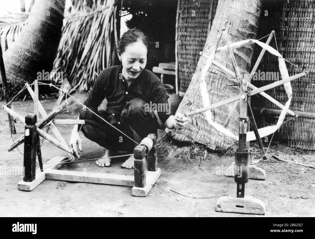 Vietnam: Filatura, Hoi An, 1930. La piccola ma storica città di ho An si trova sul fiume Thu Bon, 30 km a sud di Danang. Durante il tempo dei signori Nguyen (1558-1777) e anche sotto i primi imperatori Nguyen, Hoi An - allora conosciuto come Faifo - era un porto importante, visitato regolarmente da navi provenienti dall'Europa e da tutto l'Oriente. Verso la fine del XIX secolo, l'insabbiamento del fiume Thu Bon e lo sviluppo della vicina Danang si erano combinati per rendere Hoi An un'acqua arretrata. Foto Stock