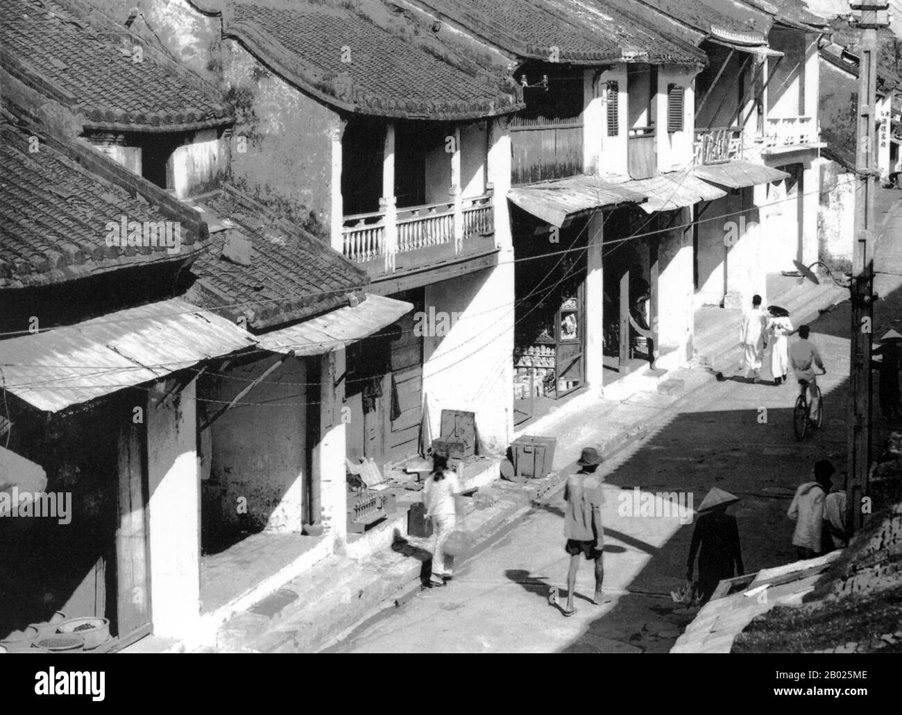 Vietnam: Nguyen Thai hoc Street, Hoi An, c. 1950. La piccola ma storica cittadina di Hoi An si trova sul fiume Thu Bon, 30 km a sud di Danang. Durante il tempo dei signori Nguyen (1558-1777) e anche sotto i primi imperatori Nguyen, Hoi An - allora conosciuto come Faifo - era un porto importante, visitato regolarmente da navi provenienti dall'Europa e da tutto l'Oriente. Verso la fine del XIX secolo, l'insabbiamento del fiume Thu Bon e lo sviluppo della vicina Danang si erano combinati per rendere Hoi An un'acqua arretrata. Questa oscurità salvò la città da seri combattimenti durante le guerre con la Francia e gli Stati Uniti. Foto Stock