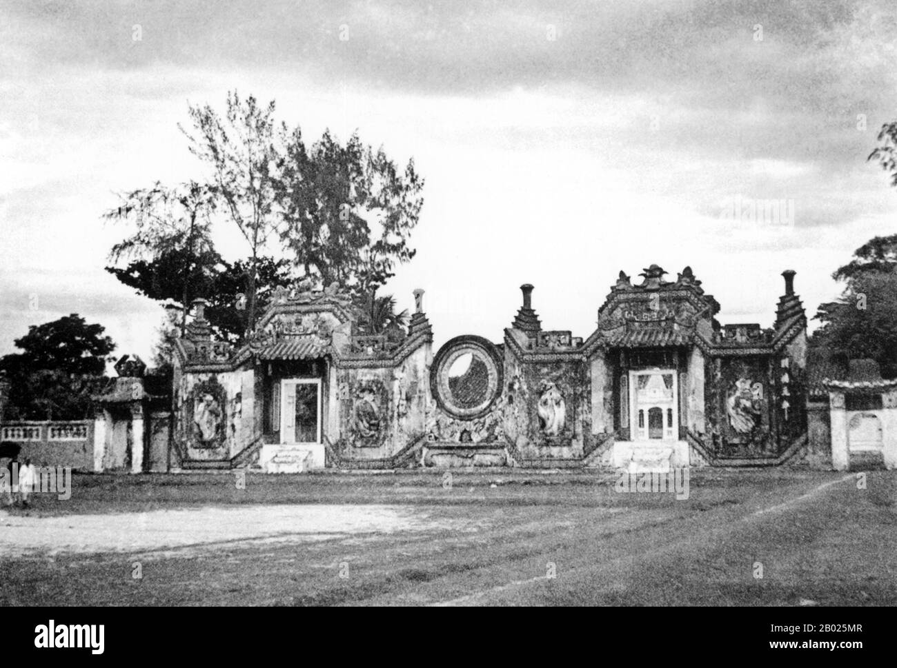 Vietnam: Porta d'ingresso al vecchio tempio di Ba Mu (Chùa Bà Mụ) o al tempio delle ostetriche, vicino a Hoi An, 1930 circa Le mười hai Bà mụ, o "dodici ostetriche", sono creature della mitologia vietnamita e della religione popolare. Sono dodici fate che insegnano ai bambini vari tratti e abilità prosperi come succhiare e sorridere. In alcune parti del Vietnam, quando un bambino ha un mese, viene eseguito un rituale speciale per le dodici ostetriche. La piccola ma storica cittadina di Hoi An si trova sul fiume Thu Bon, 30 km a sud di Danang. Foto Stock
