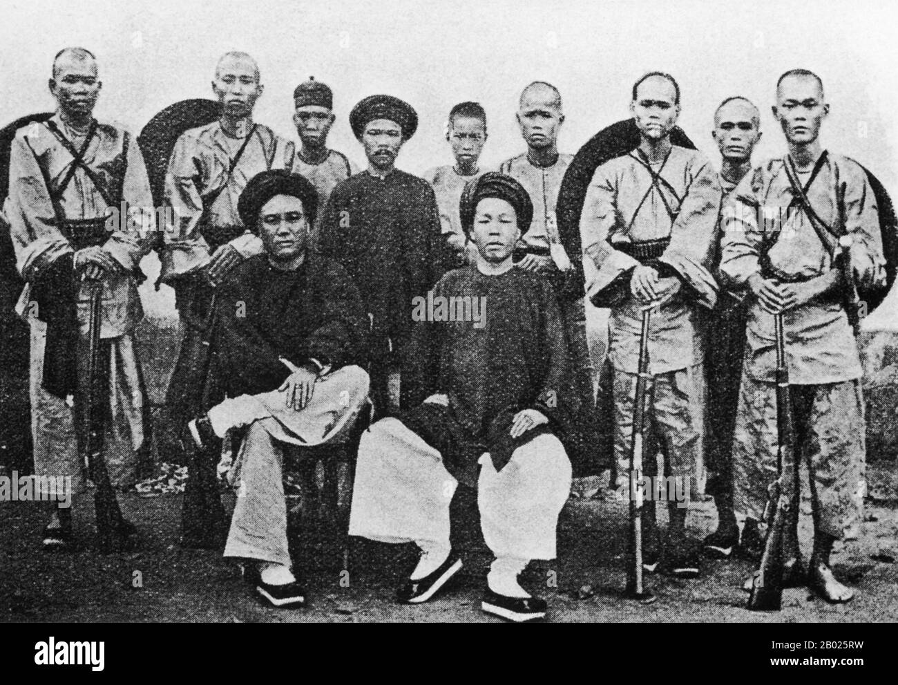 Vietnam: Milizia Tai bianca sotto il comando di Deo Van Tri (seduto a sinistra) durante le guerre Haw. Foto di Gustave Trumelet-Faber (1852-1916), c. 1890. Durante la fine del XIX secolo, tutto il territorio che si estendeva da Dien Bien Phu a sud fino alla frontiera cinese a nord formava una regione autonoma chiamata Sipsongchutai, o «dodici Principati Tai». Era governata da un principe ereditario del Tai bianco dalla sua capitale a Lai Chau e pagava un tributo, una volta o l'altra, al Siam, al Vietnam o alla Cina, e talvolta a tutti e tre. Foto Stock