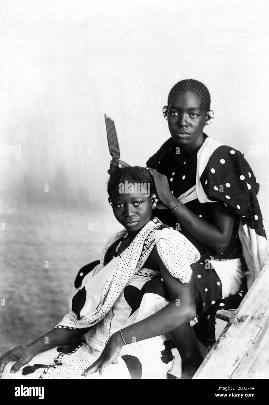 Tanzania/Zanzibar: "Natives Hair Dressing, Zanzibar". Foto di Gomes & Sons, A. C., c. 1870-1900. Zanzibar è una parte semi-autonoma della Tanzania nell'Africa orientale. È composto dall'arcipelago di Zanzibar nell'Oceano Indiano, 25-50 km (16-31 miglia) al largo della costa continentale, ed è costituito da numerose piccole isole e due grandi: Unguja (l'isola principale, indicata informalmente come Zanzibar), e Pemba. La capitale di Zanzibar, situata sull'isola di Unguja, è Zanzibar City. Il suo centro storico, conosciuto come Stone Town, è un sito Patrimonio dell'Umanità. Foto Stock