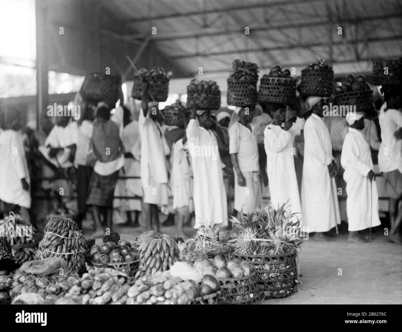 Tanzania/Zanzibar: Scena al mercato della frutta di Stone Town, 1936. Zanzibar è una parte semi-autonoma della Tanzania nell'Africa orientale. È composto dall'arcipelago di Zanzibar nell'Oceano Indiano, 25-50 km (16-31 miglia) al largo della costa continentale, ed è costituito da numerose piccole isole e due grandi: Unguja (l'isola principale, indicata informalmente come Zanzibar), e Pemba. La capitale di Zanzibar, situata sull'isola di Unguja, è Zanzibar City. Il suo centro storico, conosciuto come Stone Town, è un sito Patrimonio dell'Umanità. Foto Stock