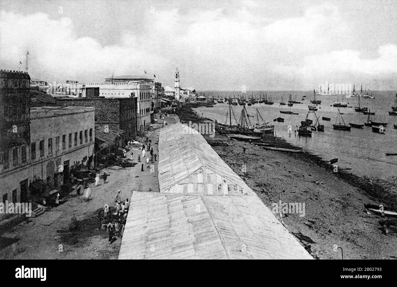 Tanzania/Zanzibar: Dhows all'ancora nel porto di Zanzibar oltre una linea di magazzini di godown, c. 1890. Zanzibar è una parte semi-autonoma della Tanzania nell'Africa orientale. È composto dall'arcipelago di Zanzibar nell'Oceano Indiano, 25-50 km (16-31 miglia) al largo della costa continentale, ed è costituito da numerose piccole isole e due grandi: Unguja (l'isola principale, indicata informalmente come Zanzibar) e Pemba. La capitale di Zanzibar, situata sull'isola di Unguja, è Zanzibar City. Il suo centro storico, conosciuto come Stone Town, è un sito Patrimonio dell'Umanità. Foto Stock