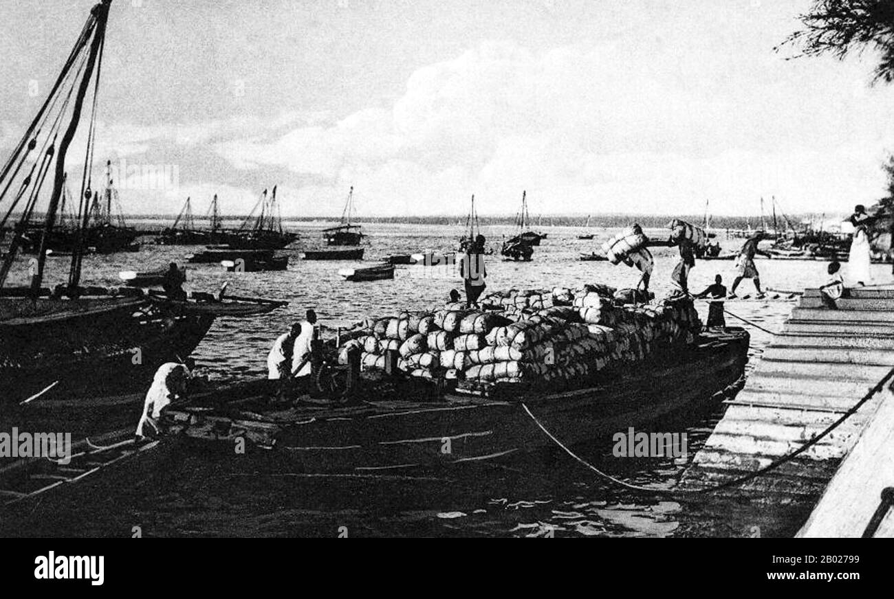Tanzania/Zanzibar: Caricamento chiodi di garofano per la spedizione al porto di Zanzibar, c. 1905. Zanzibar è una parte semi-autonoma della Tanzania nell'Africa orientale. È composto dall'arcipelago di Zanzibar nell'Oceano Indiano, 25-50 km (16-31 miglia) al largo della costa continentale, ed è costituito da numerose piccole isole e due grandi: Unguja (l'isola principale, indicata informalmente come Zanzibar), e Pemba. La capitale di Zanzibar, situata sull'isola di Unguja, è Zanzibar City. Il suo centro storico, conosciuto come Stone Town, è un sito Patrimonio dell'Umanità. Foto Stock