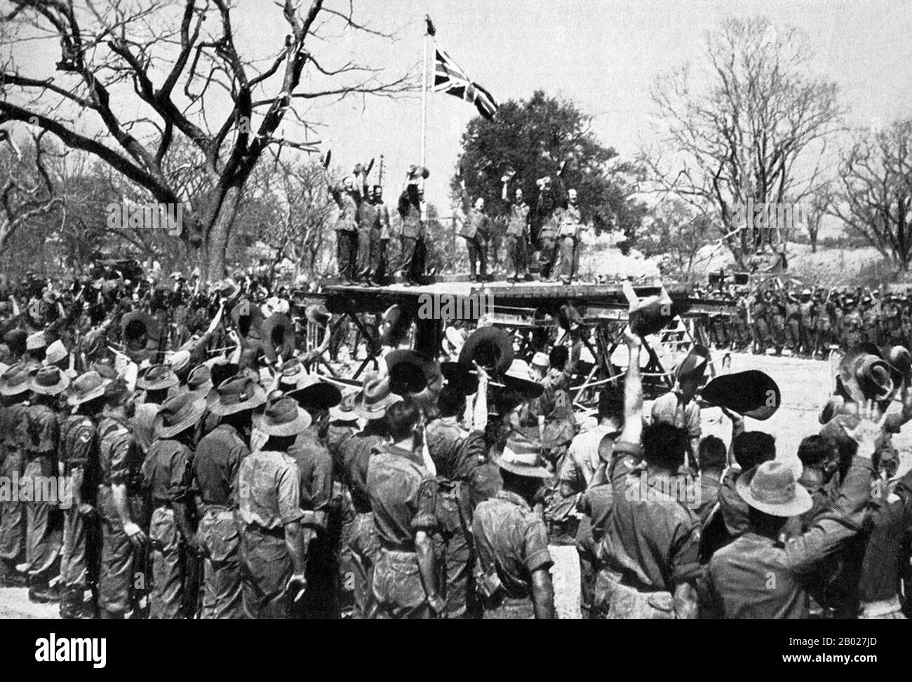 Birmania/Myanmar: La battaglia di Mandalay (seconda guerra mondiale). Alzare la bandiera a Fort Dufferin (Mandalay Palace), Mandalay. Il generale Slim guida l'applauso, 20 marzo 1945. La caduta di Mandalay il 20 marzo 1945 fu il culmine di un'avanzata di 640 chilometri (400 miglia) contro l'opposizione sempre crescente che portò la 19a divisione indiana dell'esercito indiano britannico dalle rive del fiume Chindwin alle mura di Fort Dufferin a Mandalay. Sia il 1st che il 4th Battalions del 6th Gurkha Rifles servirono nella 19th Indian Division durante questo periodo. Foto Stock