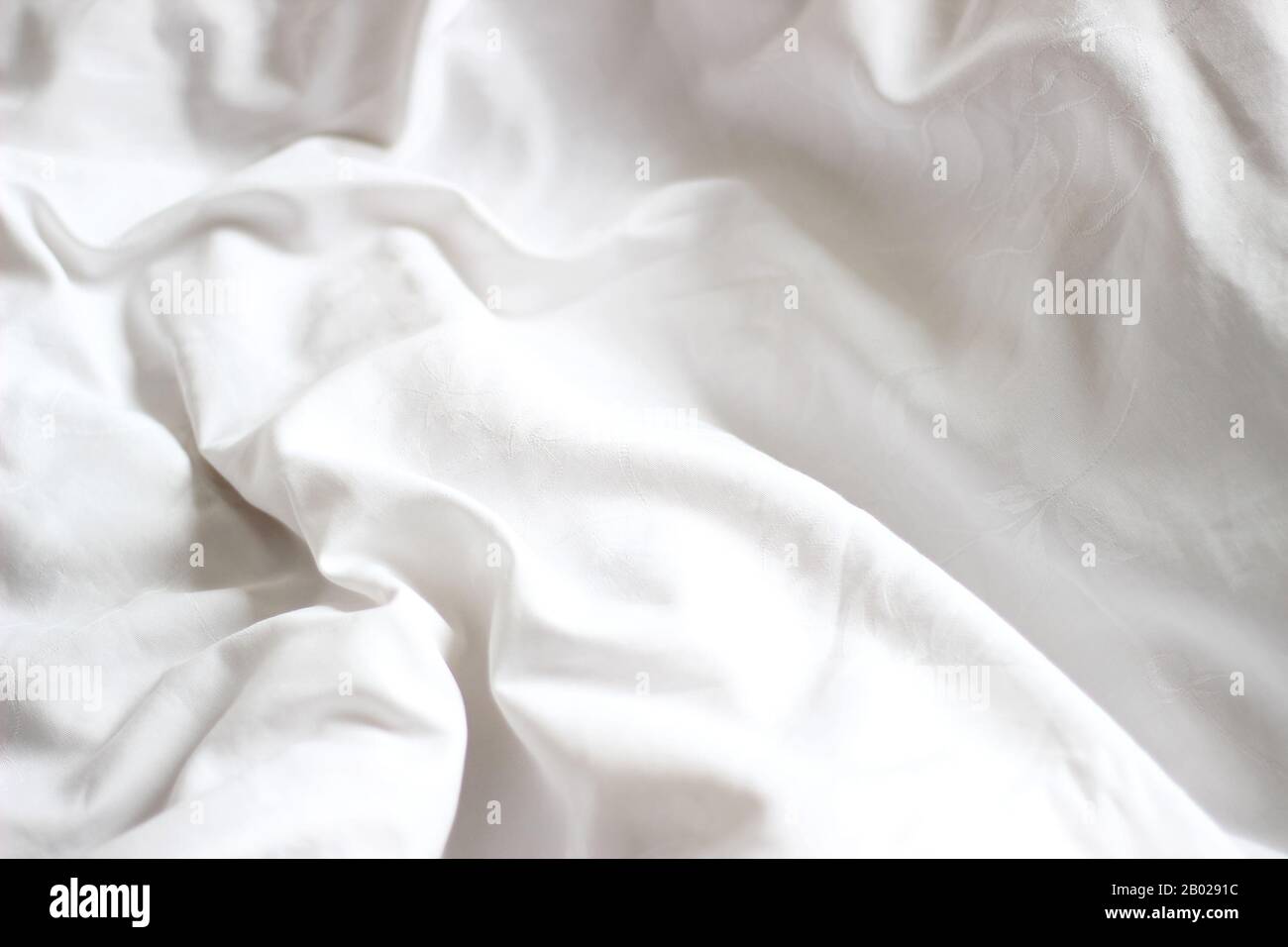 Soffici lenzuola bianche su un letto non fatto. Design Scandinavo Minimo. Concetto Di Hygge. Foto Stock