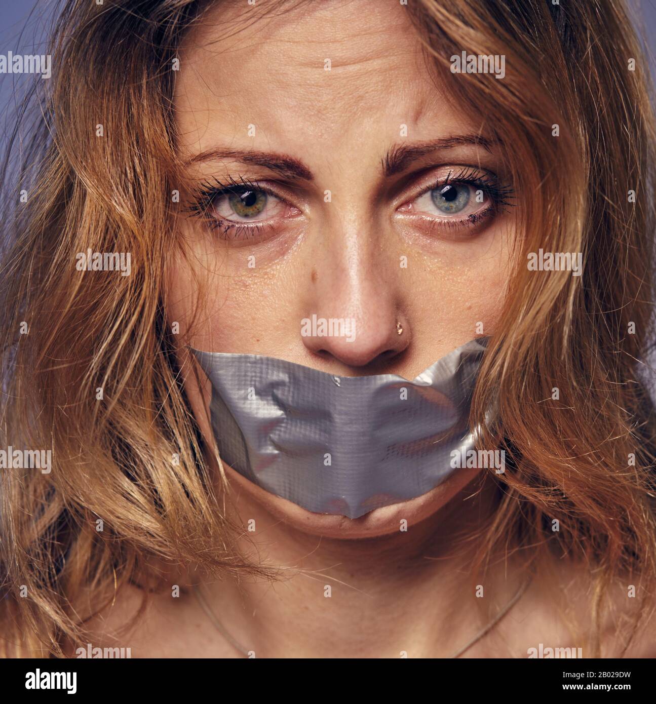 donna e violenza. foto di una donna con le sue labbra attaccate insieme. Foto Stock