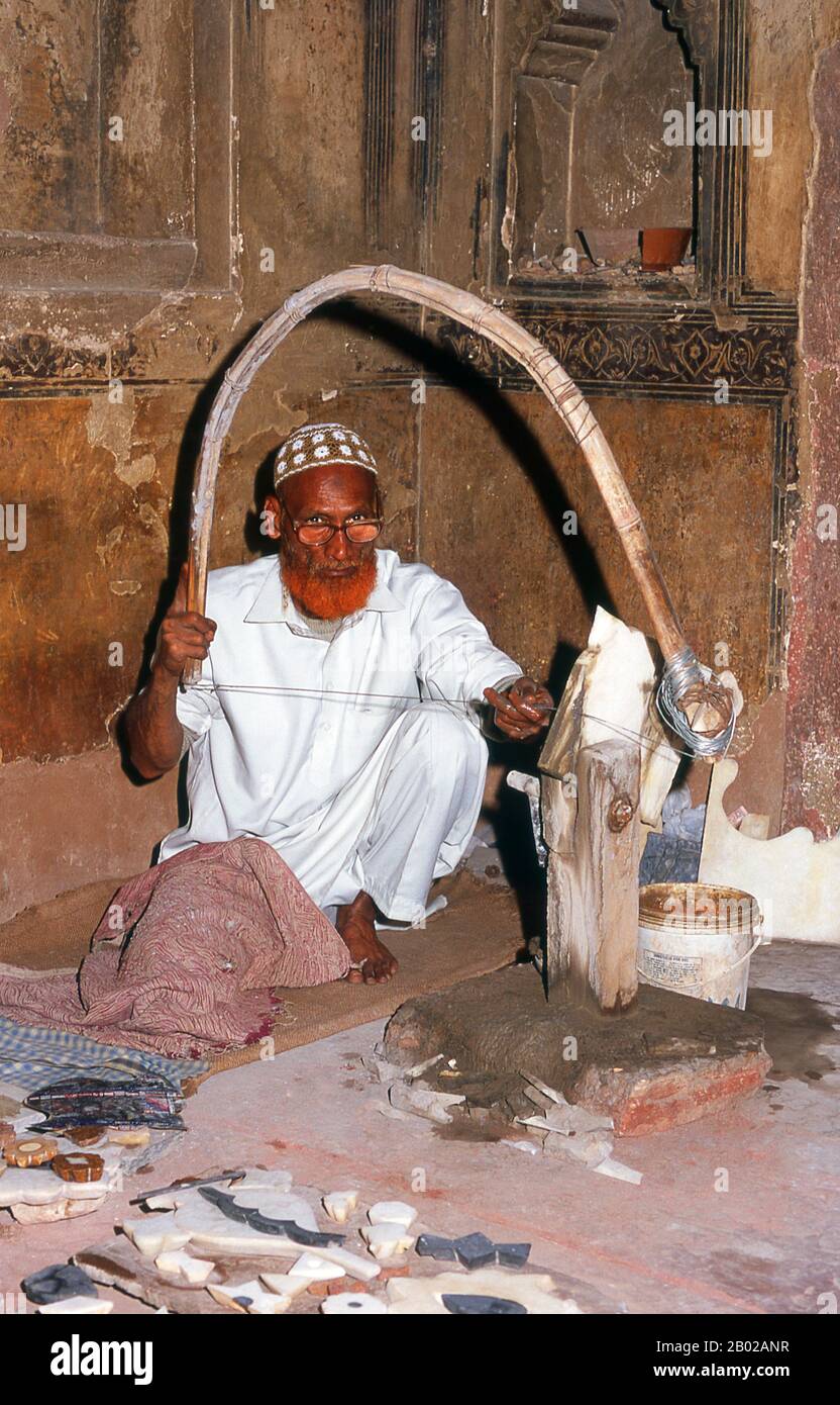 India: Un artigiano di marmo presso la tomba di i'timad-ud-Daulah, Agra. La tomba di Etimad-ud-Daula è un mausoleo moghul nella città di Agra nello stato indiano dell'Uttar Pradesh. Insieme all'edificio principale, la struttura è costituita da numerosi annessi e giardini. La tomba, costruita tra il 1622 e il 1628, rappresenta una transizione tra la prima fase della monumentale architettura mughal - costruita principalmente in arenaria rossa con decorazioni in marmo, come nella tomba di Humayun a Delhi e nella tomba di Akbar a Sikandra - alla sua seconda fase, basata su marmo bianco e intarsi di pietra dura. Foto Stock