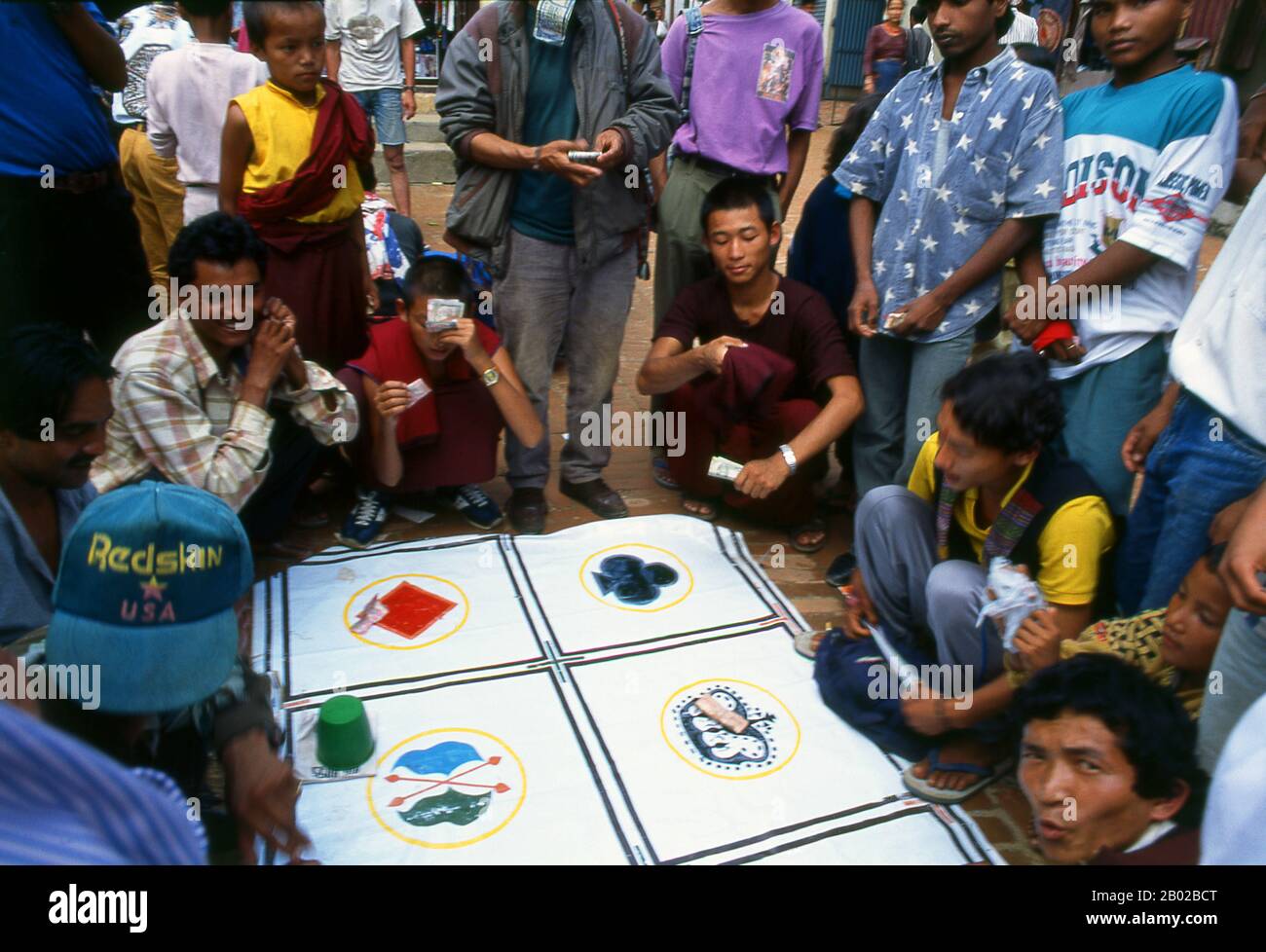 Nepal: Gioco d'azzardo a Bodhnath (Boudhanath), Kathmandu. Situato direttamente nel siddhi, una zona di potere soprannaturale dove le divinità custodi dimorano e i desideri sono garantiti, Bodhnath si trova a soli sei chilometri ad est di Kathmandu, lungo la lunga e vecchia strada commerciale per Lhasa. Conosciuta dai tibetani semplicemente come Chorten Chempo, o "grande Stupa", è stata la Mecca dei tibetani in esilio sin dall'occupazione cinese della loro patria nel 1950. Bodhnath si è anche sviluppato come centro per lo studio del buddismo tibetano, essendo stati costruiti numerosi monasteri in sostituzione di quelli distrutti. Foto Stock