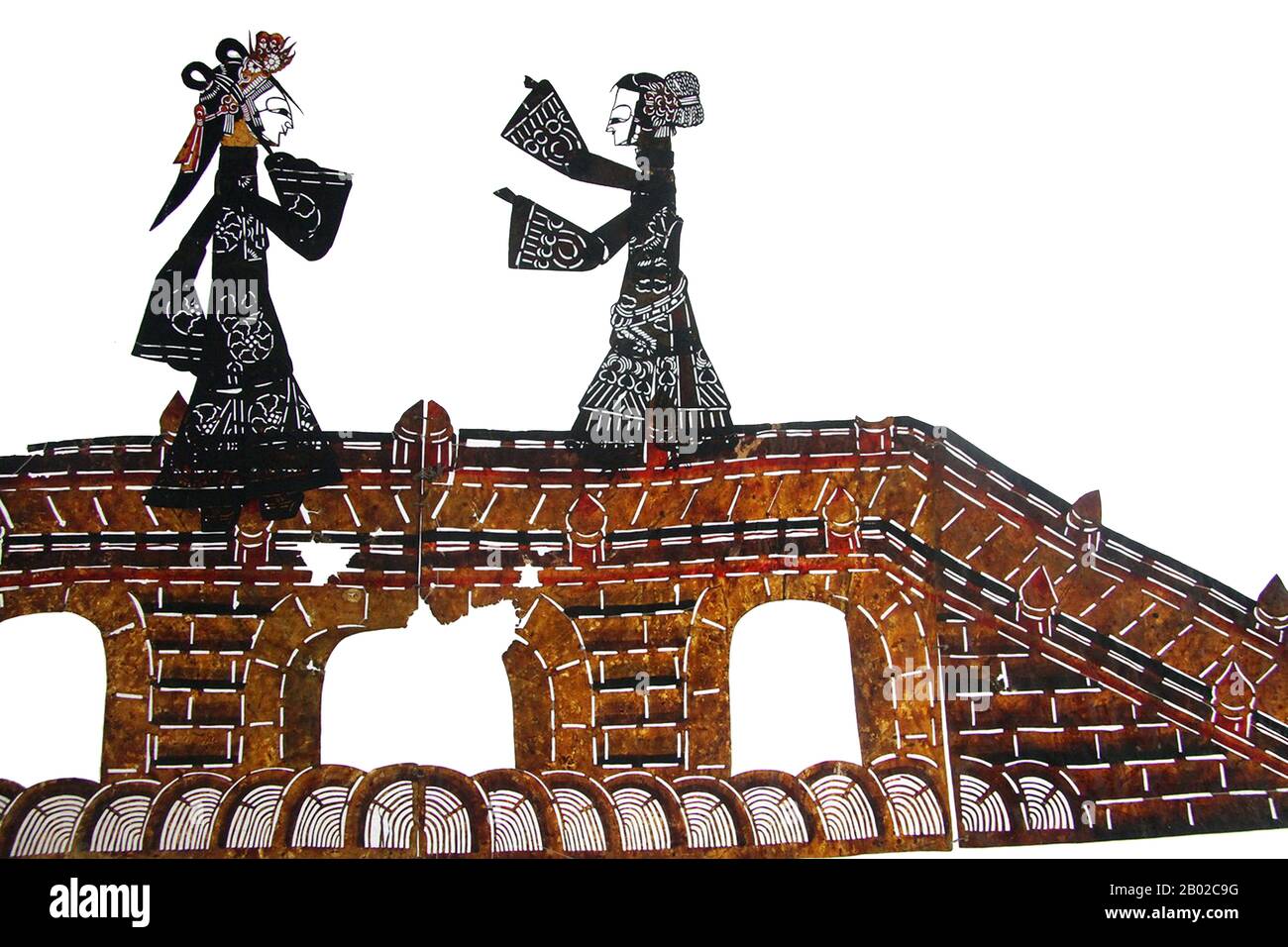 Cina: Marionette ombra di due donne su un ponte, Cina nord-orientale, XX secolo. Il gioco d'ombra (cinese: Pí yĭng xì) o burattini d'ombra è un'antica forma di narrazione e intrattenimento che utilizza figure opache e spesso articolate di fronte a uno sfondo illuminato per creare l'illusione di immagini in movimento. È popolare in varie culture. Attualmente, più di 20 paesi sono noti per avere troupe ombra. I burattini d'ombra hanno avuto origine durante la dinastia Han quando una delle concubine dell'imperatore Wu di Han è morta per una malattia. Foto Stock