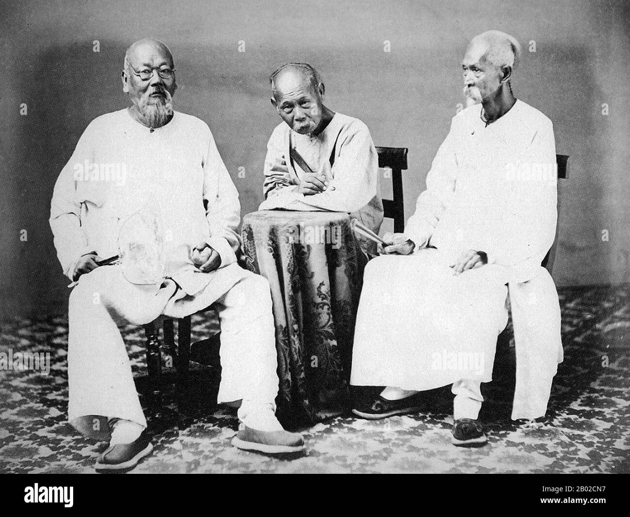 Cina: Tre prosperi mercanti di Canton/Guangzhou, provincia del Guangdong, poco dopo la fine della seconda guerra dell'oppio (1856-1860), 1861. La seconda guerra dell'oppio, la seconda guerra anglo-cinese, la seconda guerra cinese, la guerra con la freccia, o la spedizione anglo-francese in Cina, fu una guerra che vide l'Impero britannico e il secondo Impero francese contro la dinastia Qing cinese, durata dal 1856 al 1860. Foto Stock