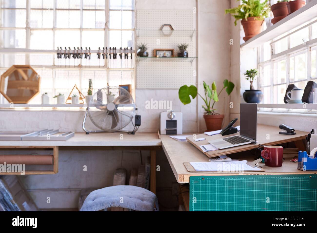 Laptop seduto su un tavolo all'interno di un negozio di cornici Foto Stock
