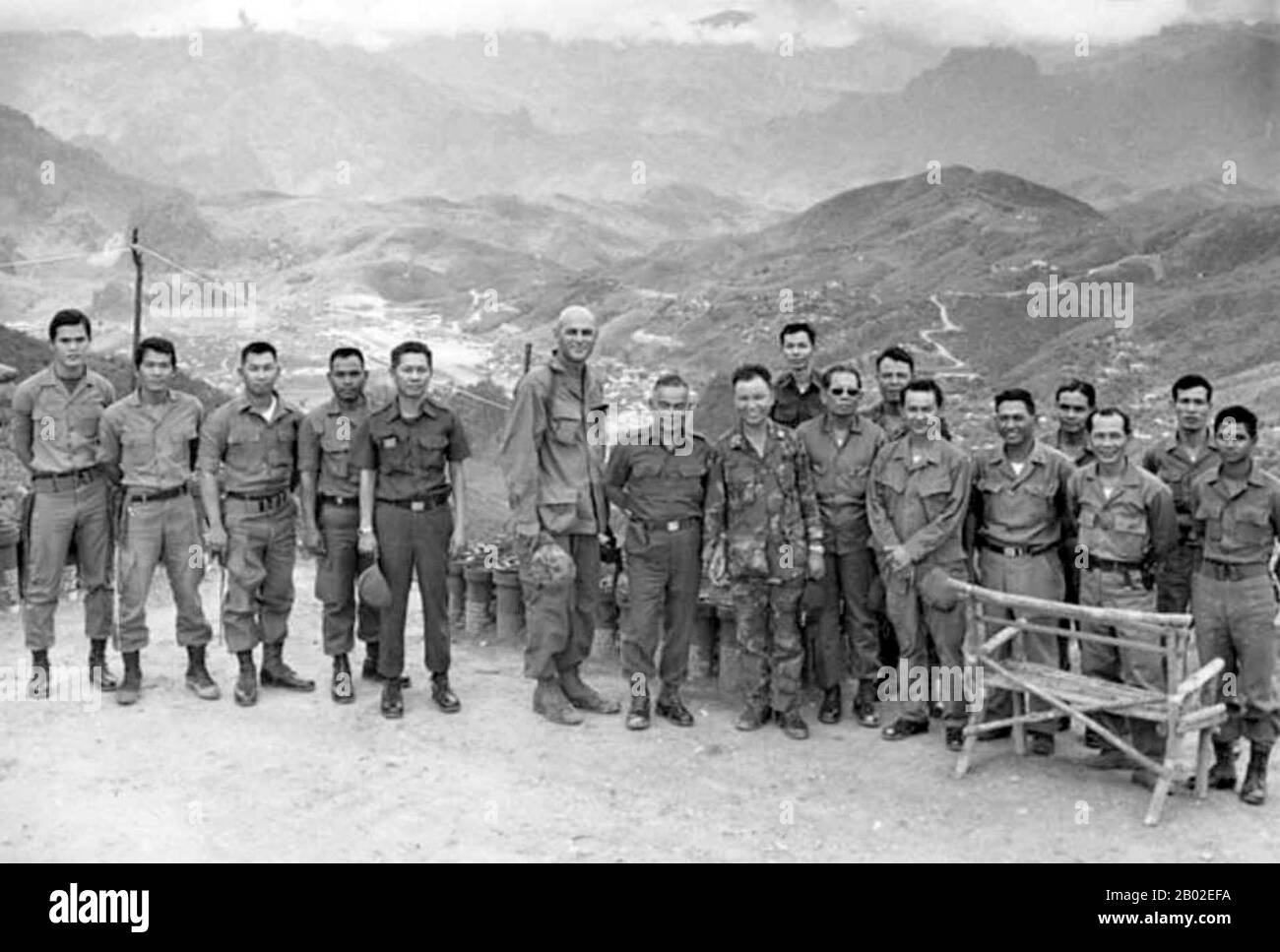 Il generale di destra Hmong Vang Pao è raffigurato che tiene le mani con il capo Di Personale dell'esercito tailandese Surakij Mayalab in un luogo che domina la sede di Hmong–CIA a Long Tien, Laos. A sinistra di Mayalab c'è il caso ufficiale della CIA Burr Smith (con testina rasata). Il resto degli uomini nella foto sono soldati thailandesi che servivano in Laos con le forze Lao-Hmong. Vang Pao (Hmong: Vaj Pov; 8 dicembre 1929 – 6 gennaio 2011) è stato un tenente generale dell'Armata reale del Laos e figura di spicco della 'Guerra segreta' americana in Laos (1964-1973). È stato leader nella comunità americana Hmong negli Stati Uniti. Foto Stock