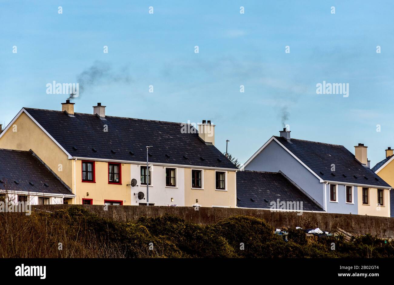 Fumo dalla combustione di combustibili fossili soffia nel cielo di Ardara, County Donegal, Irlanda Foto Stock
