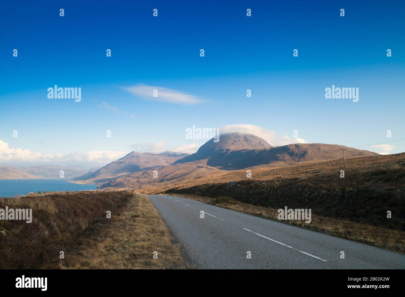 La A832 nelle Highlands scozzesi con Il Piccolo Loch Broom e la montagna Sail Mhor sullo sfondo Foto Stock