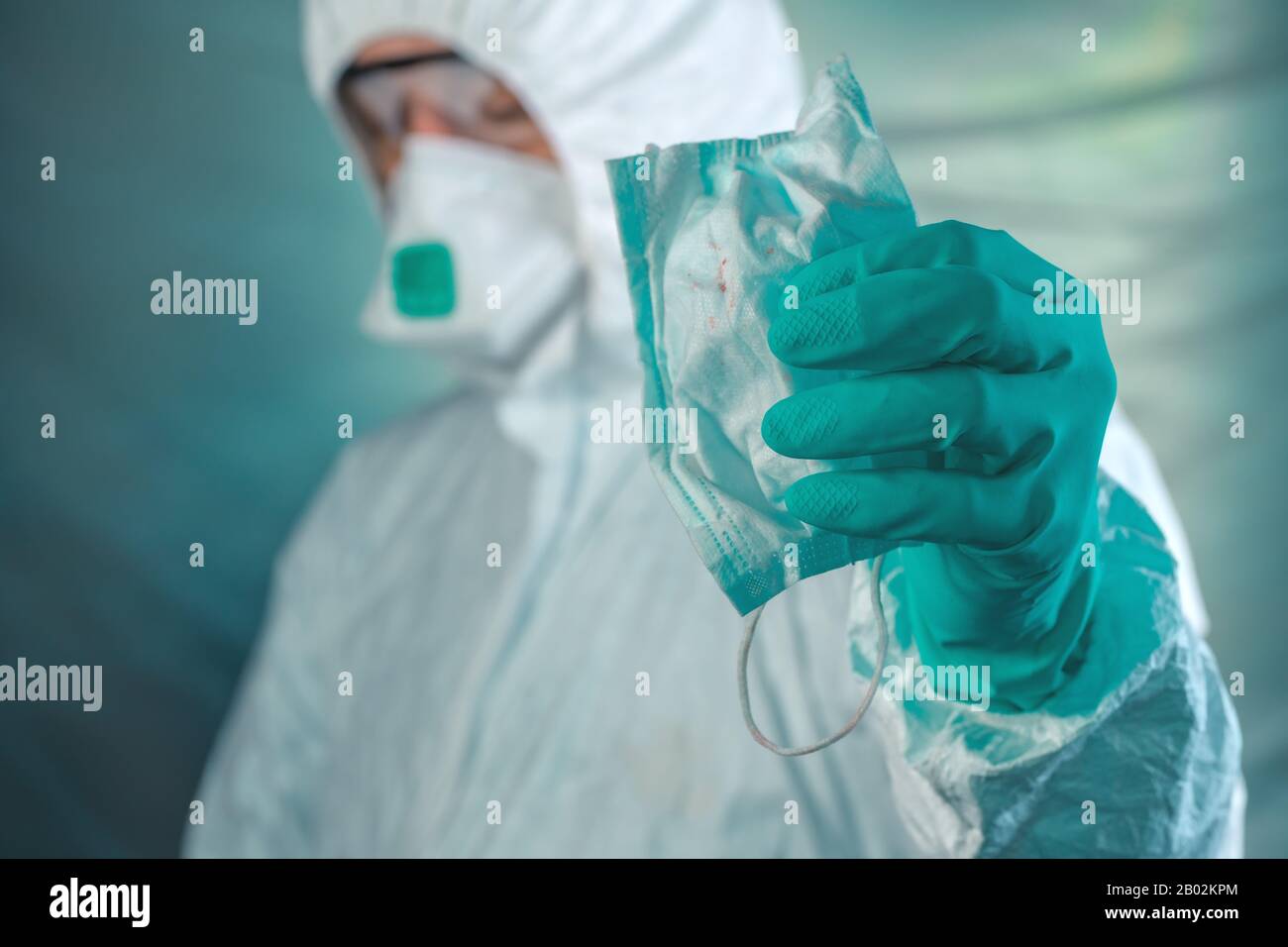 Epidemiologo che tiene maschera respiratoria con macchie di sangue nel concetto di coronavirus di wuhan Foto Stock