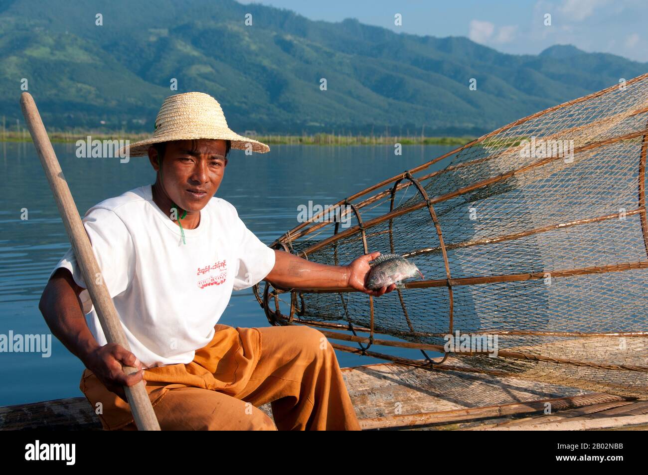 Il lago Inle a 116 kmq è poco profondo, lungo, cristallino e calmo. Qui il popolo Intha vive, incastonato su entrambi i lati da alte colline. Gli uomini Intha sono famosi per il canottaggio in piedi, utilizzando una gamba, mentre la pesca con trappole coniche alte per carpe Inle e l'altra, pesci più piccoli con cui il lago sciami. Le donne Intha, giardinieri campione del mercato, usano il terreno fertile intorno al lago, così come le isole galleggianti fatte di acqua giacinti e fango, per crescere cavolfiore, pomodori, cetrioli, cavoli, fagioli e melanzane. Inle è un posto semplice, ma un posto pieno di abbondanza - entrambi riposanti Foto Stock