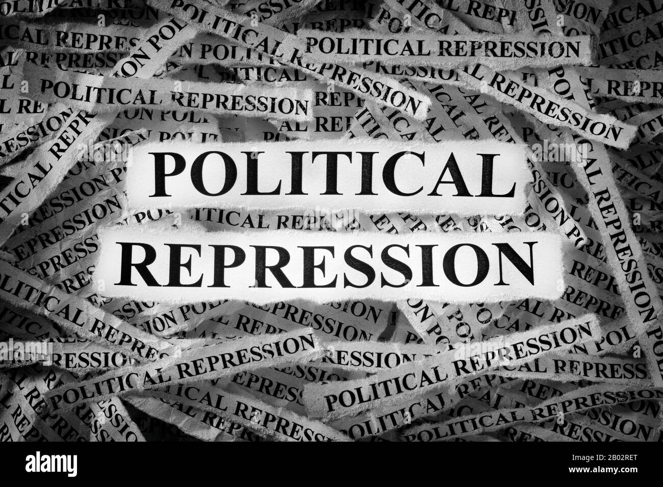 Strisce di giornali con le parole Repressione Politica tipizzate su di loro. Bianco e nero. Primo piano. Foto Stock