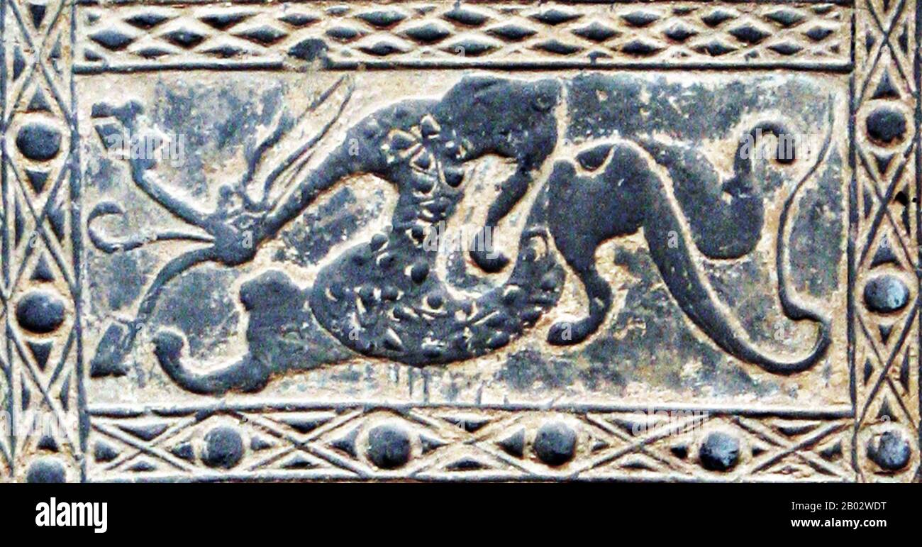 Una piastrella in ceramica della dinastia Han, raffigurante scene di caccia e battaglia contenenti figure emblematiche delle "cinque direzioni cardinali" (le quattro direzioni cardinali più il centro). I Quattro simboli (cinese: 四象; pinyin: Sì Xiàng) sono quattro creature mitologiche nelle costellazioni cinesi. Sono il Drago Azzurro, l'Oriente, l'uccello vermiglio del Sud, la Tigre Bianca dell'Ovest e la tartaruga Nera del Nord. Ognuno di essi rappresenta una direzione e una stagione, e ognuno ha le proprie caratteristiche e origini individuali. Simbolicamente e come parte di spirituale e religioso Foto Stock