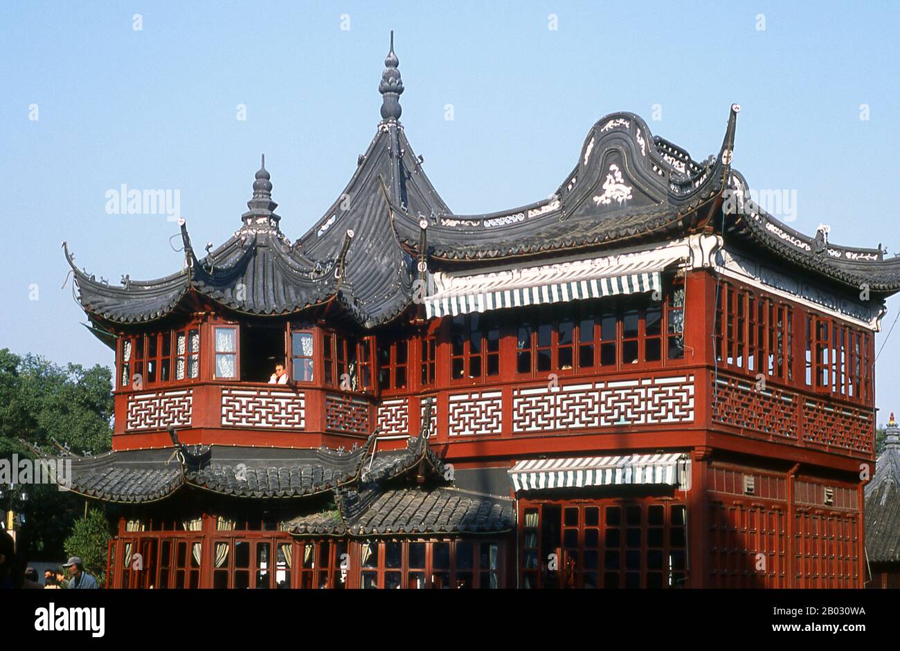 La Huxinting Tea House di Shanghai si trova nel mezzo di un lago pieno di pesci rossi sul bordo del Giardino Yuyuan di Nanshi, la vecchia città cinese. (2006) Shanghai ha iniziato a vivere come villaggio di pescatori, e più tardi come porto che riceve merci trasportate lungo il fiume Yangzi. Dal 1842 in poi, all’indomani della prima guerra dell’Opium, i britannici aprirono una ‘concessione’ a Shanghai dove i commercianti di droga e altri commercianti potevano operare indisturbati. Seguirono francesi, italiani, tedeschi, americani e giapponesi. Negli anni Venti e trenta, Shanghai era una città in espansione e una città internazionale per la dissipazione. Foto Stock