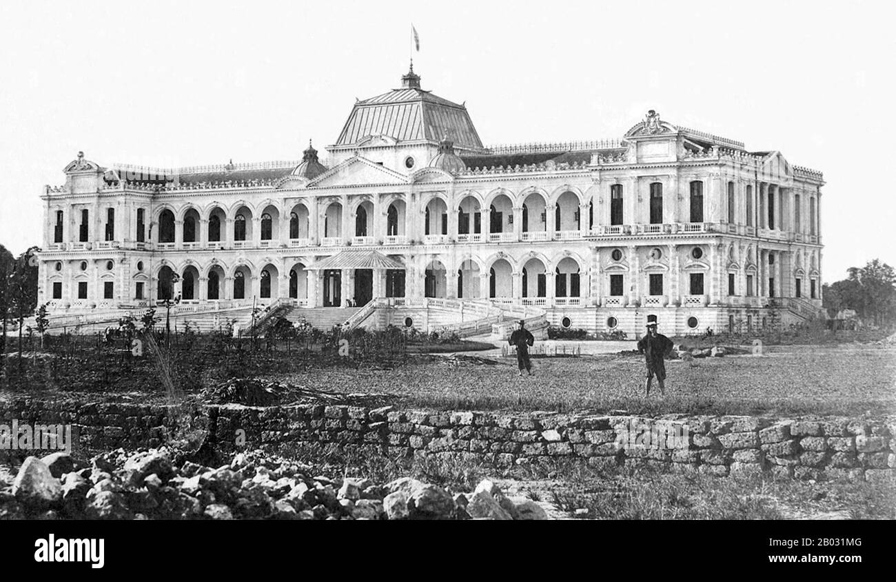 Nel 1858, la Francia lanciò un attacco a Đà Nẵng, iniziando la sua invasione del Vietnam. Nel 1867, la Francia completò la sua conquista del Vietnam meridionale (Cochinchina), comprendente le province di Biên Hoà, Gia Định, Định Tường, Vĩnh Long, An Giang e Hà Tiên. Per consolidare la nuova colonia, il 23 febbraio 1868, Lagrandière, Governatore di Cochinchina, ha tenuto una cerimonia per porre la pietra di fondazione di un nuovo palazzo per sostituire l'antico palazzo in legno costruito nel 1863. Il nuovo palazzo è stato progettato da Hermite, che è stato anche l'architetto del Municipio di Hong Kong. La prima pietra cubica, di 50 cm alo Foto Stock