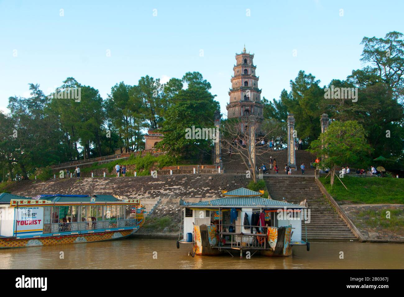 La Pagoda di Thien Mu vista da un drago sul fiume Perfume. La Pagoda di Thien Mu fu costruita nel 1601 sotto Nguyen Hoang, il governatore della provincia di Thuan Hoa, ora nota come Hue. Anche se giurò fedeltà alla dinastia le ad Hanoi, Nguyen Hoang governò effettivamente Thuan Hoa come stato indipendente nel Vietnam centrale. La pagoda ha sette storie ed è la più alta del Vietnam, ed è spesso oggetto di rime popolari e poesie su Hue, che fu la capitale imperiale del Vietnam tra il 1802 e il 1945. Foto Stock