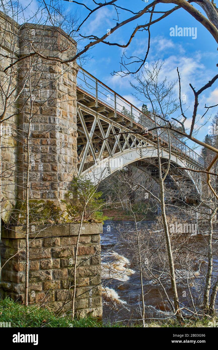 CARRON VILLAGE MORAY SCOZIA ALBERI D'INVERNO SULLA RIVA DEL FIUME CIRCONDANO L'UNICA STRADA CARRON E L'ANTICO PONTE FERROVIARIO CHE ATTRAVERSA IL FIUME SPEY Foto Stock