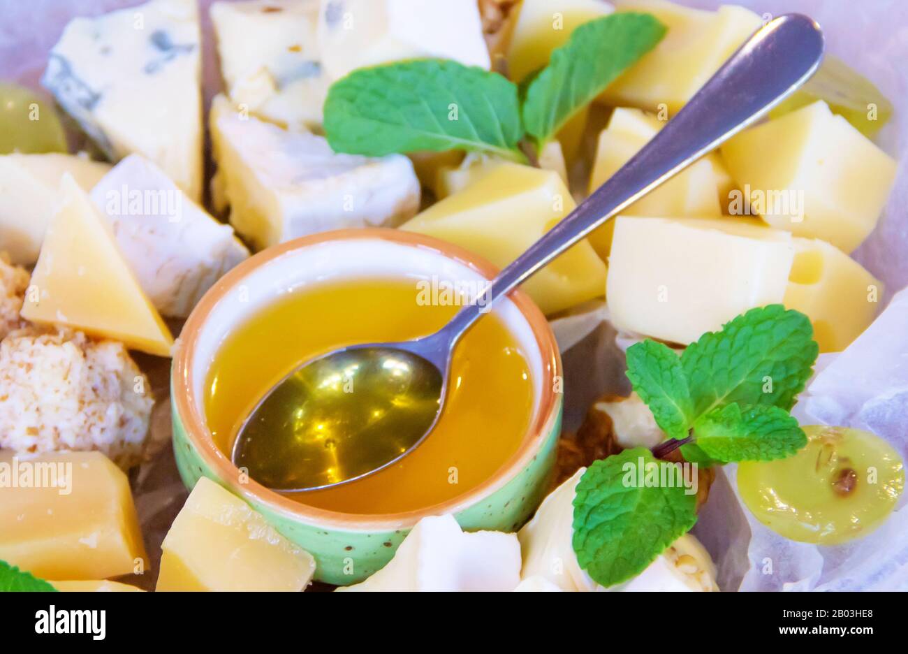 Molti tipi di formaggio Parmigiano, Gouda, Emmental formaggio con miele, noci e physalis. Antipasto in un ristorante francese, spuntino per vino. Piatto per Foto Stock