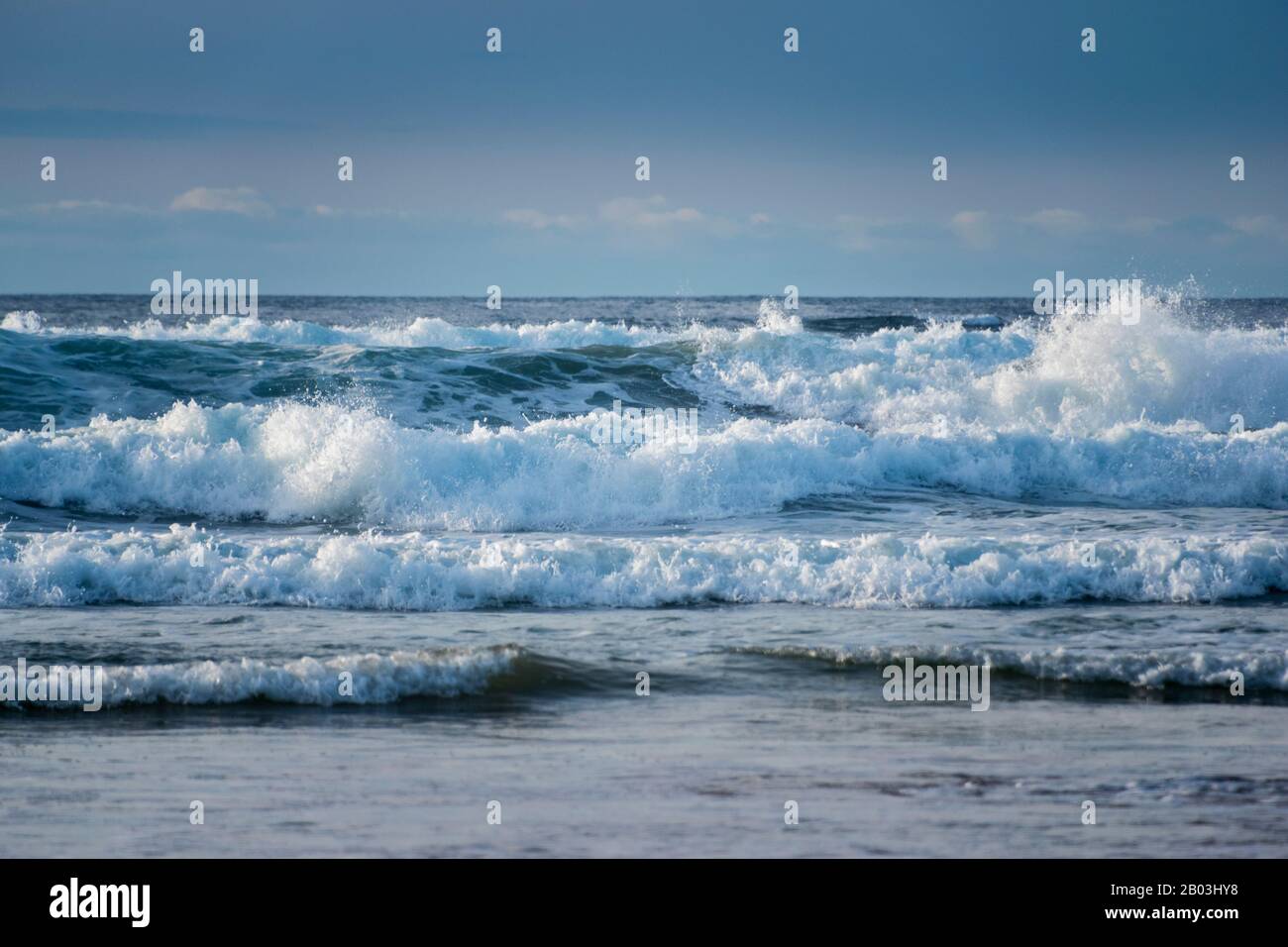 Onde che si infrangono con la bassa marea a St Ives Bay, in Cornovaglia. Foto Stock