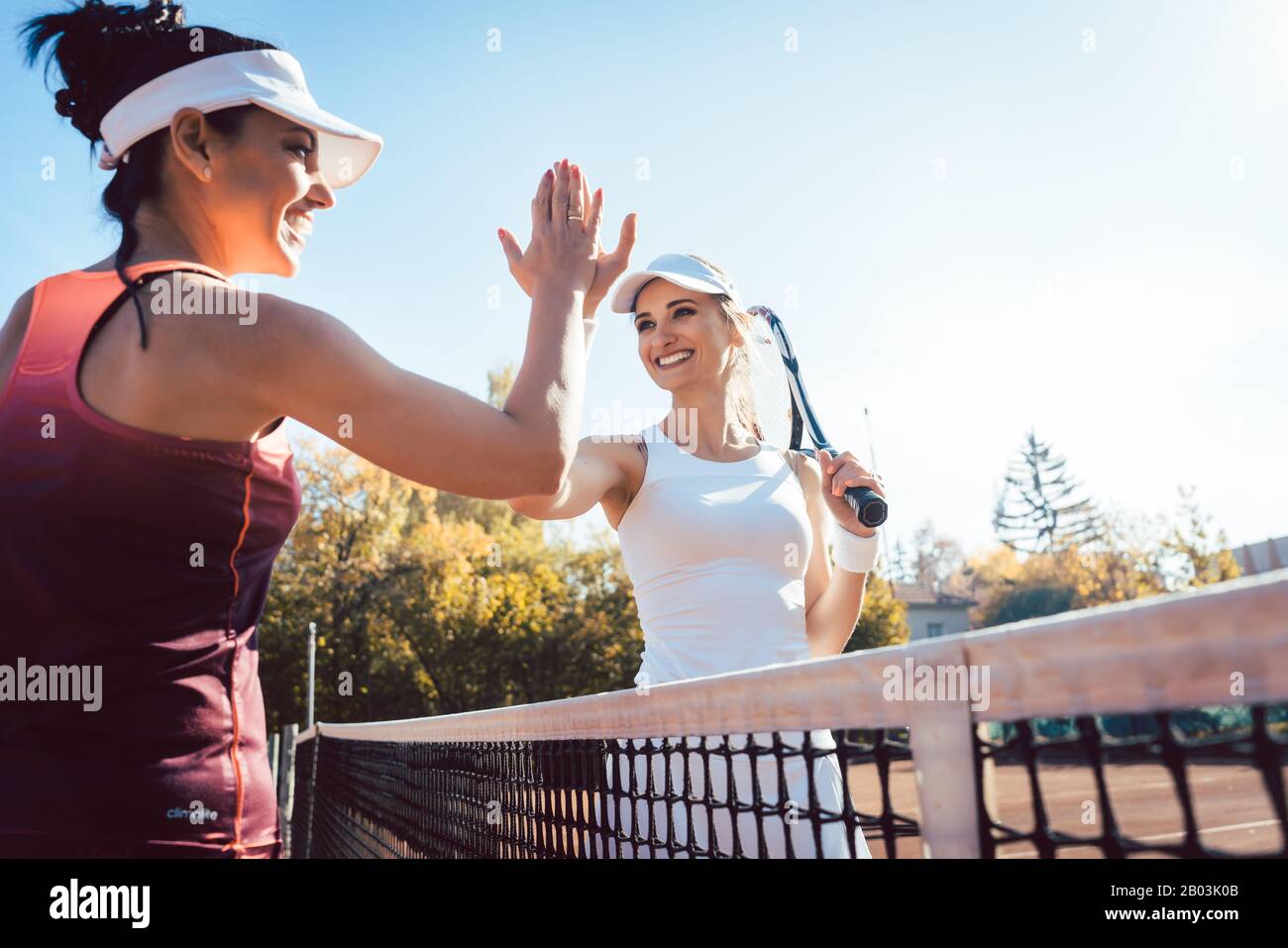 Donne che danno cinque alto dopo una buona partita di tennis Foto Stock