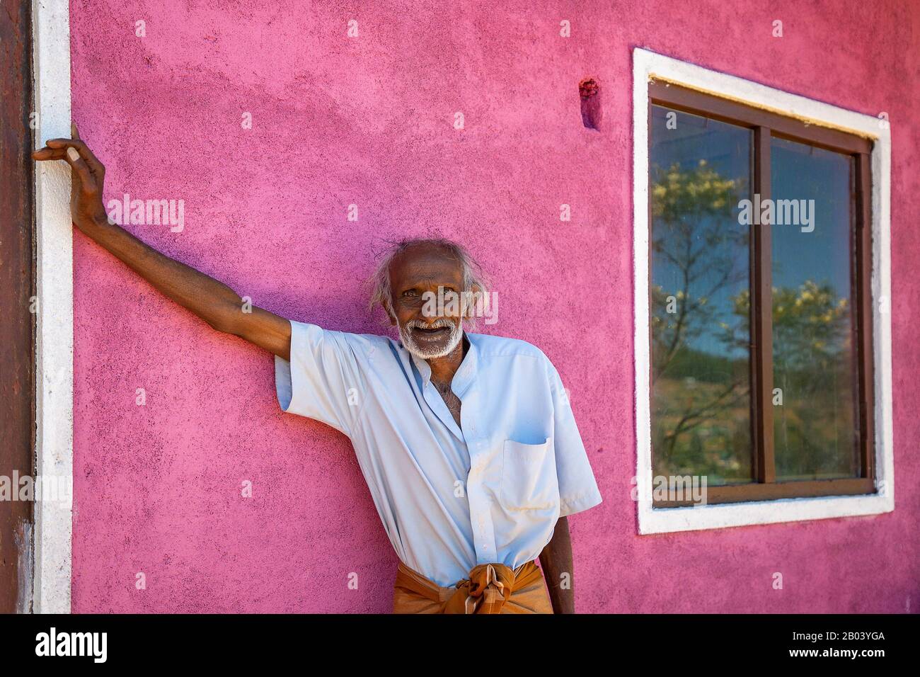 Uomo anziano contro muro rosa, nel villaggio di Nuwara Eliya, Sri Lanka Foto Stock