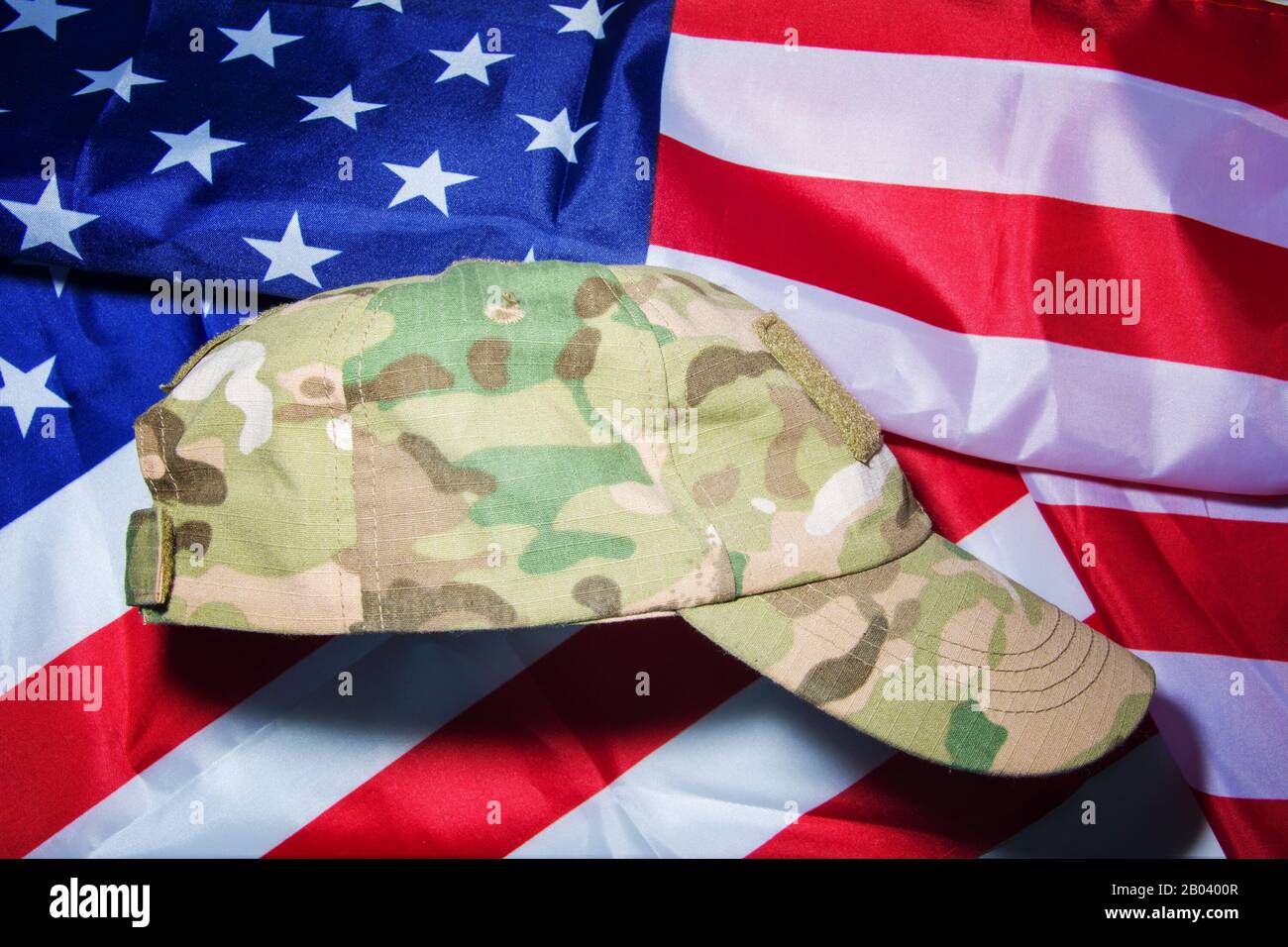 Cappello militare camouflage di Noi soldato esercito su sfondo americano bandiera. Foto Stock
