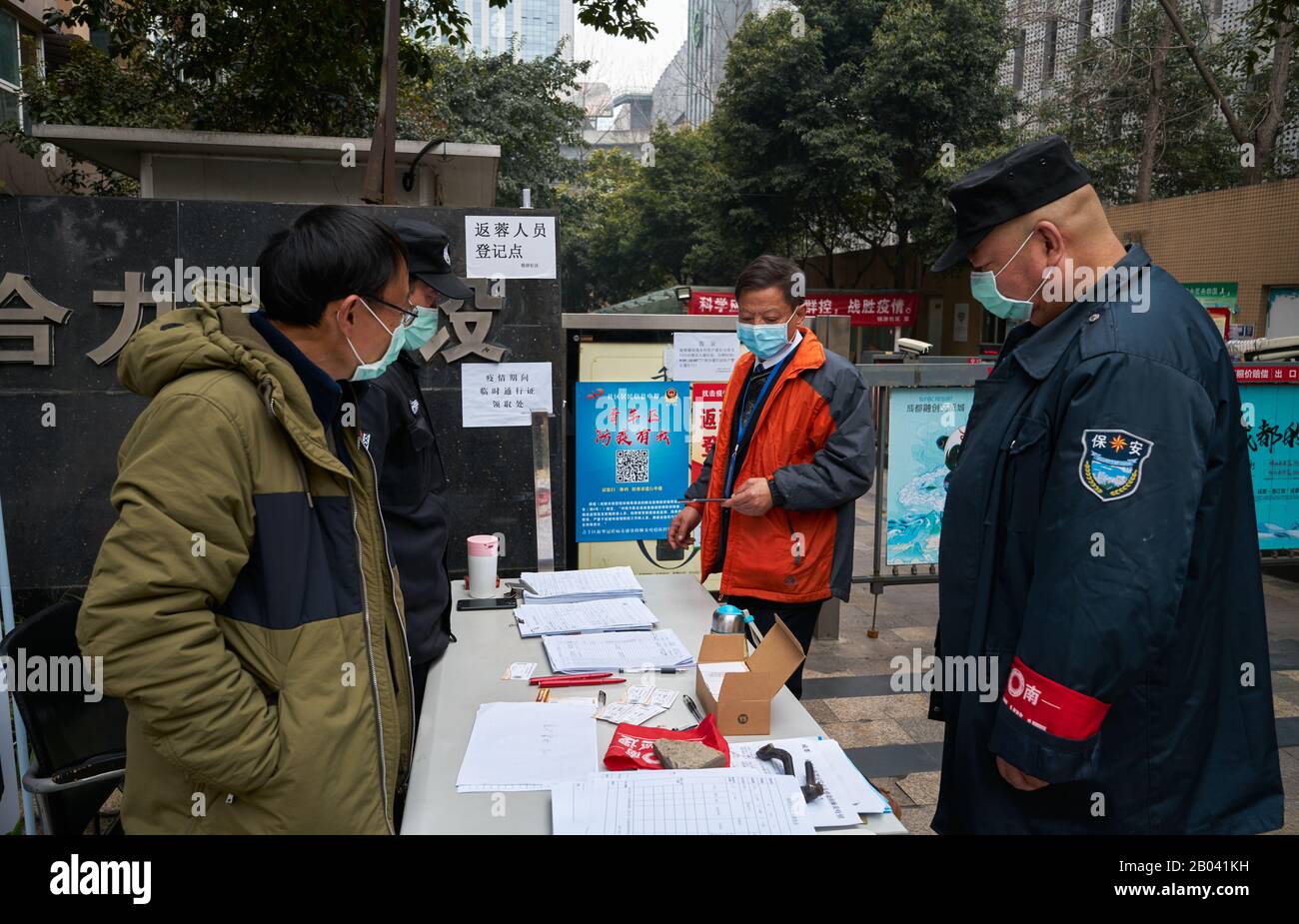 COVID-19 a Wuhan si sta diffondendo in tutto il mondo. Team di sicurezza che controlla l'infezione da coronavirus in un'entrata residenziale complessa. Foto Stock