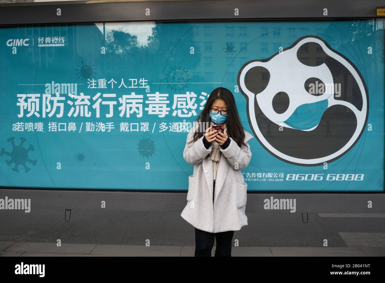 La malattia del coronavirus COVID-19 a Wuhan si sta diffondendo in tutto il mondo. Giovane donna che indossa maschera chirurgica presso la stazione degli autobus di Chengdu. Foto Stock