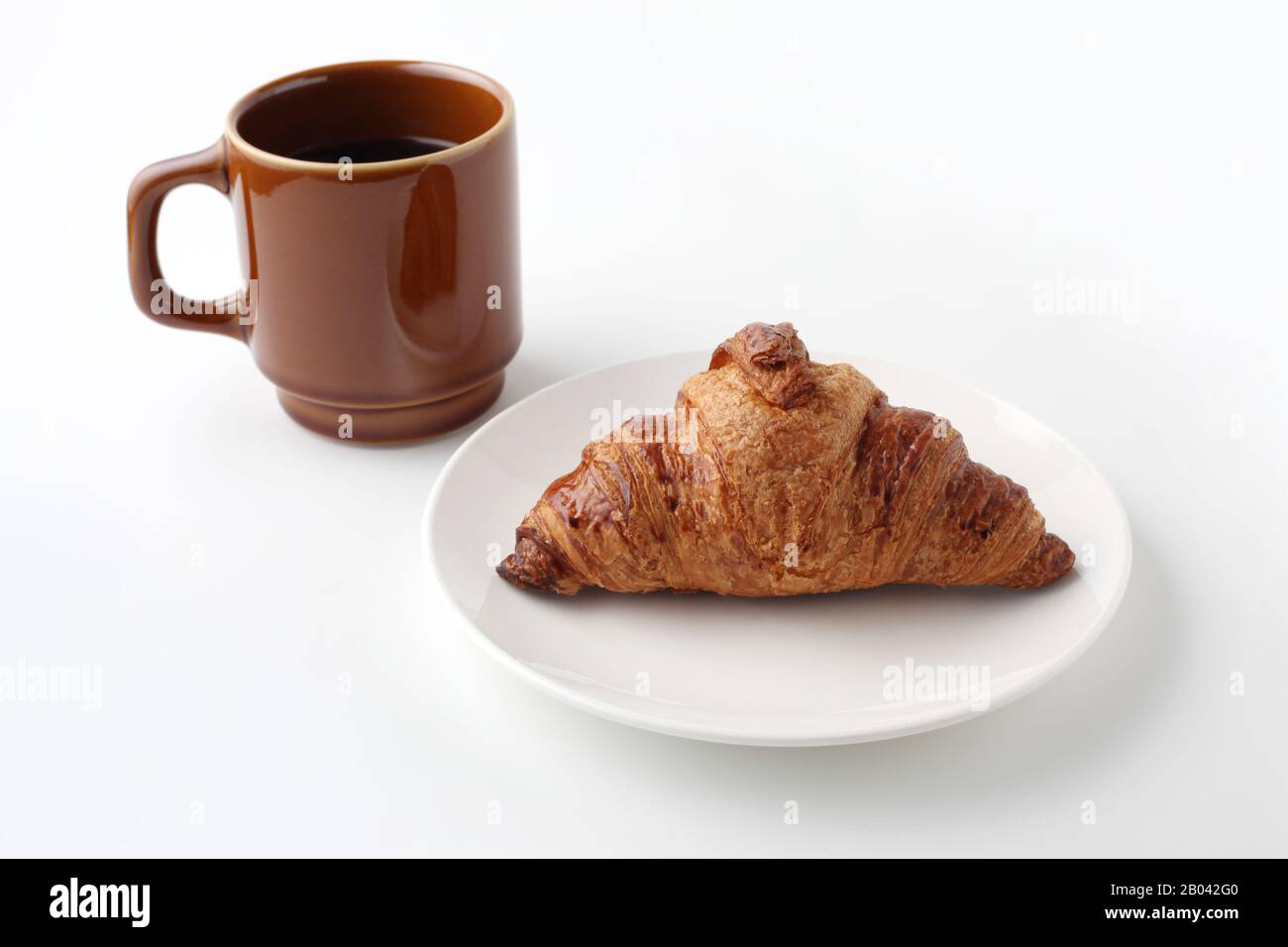 croissant pane francese su piatto e caffè caldo isolato su sfondo bianco Foto Stock