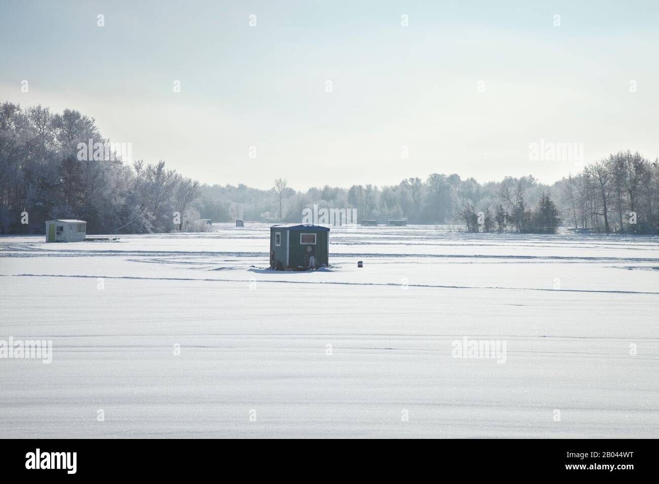 Stacchi e rimorchi per la pesca del ghiaccio in un lago del Minnesota in una luminosa mattinata invernale Foto Stock