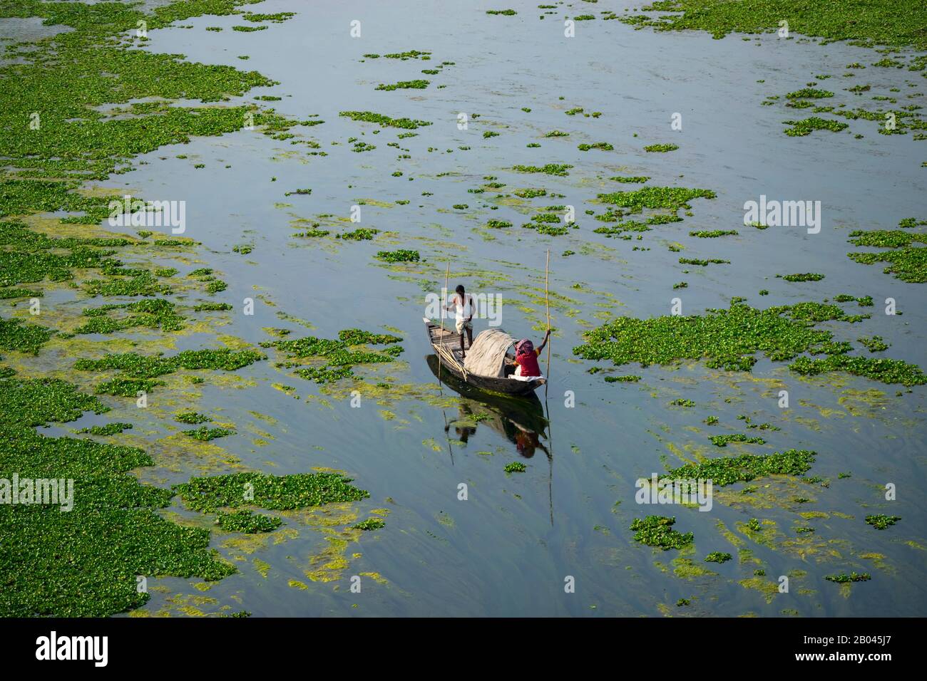 Pescatori alla ricerca di pesci in vecchio modo tradizionale (a cavallo su una barca) in Bangladesh. Foto Stock