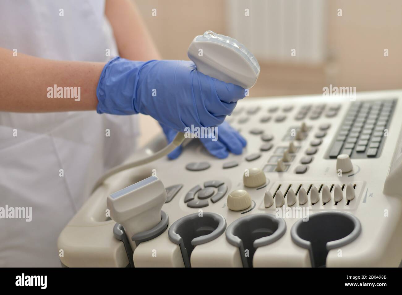 Il medico al lavoro su uno scanner a ultrasuoni, il primo piano è nitido. Foto Stock