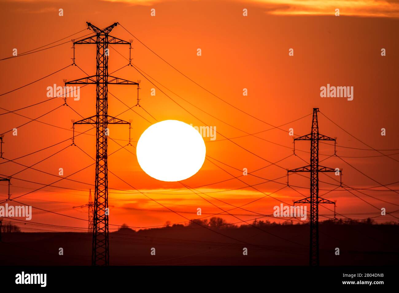 Vista in una silhouette di linee elettriche e colonne Colonna durante il tramonto con nuvole sul cielo. Bella natura tramonto. Paesaggio rurale con elettrico Foto Stock
